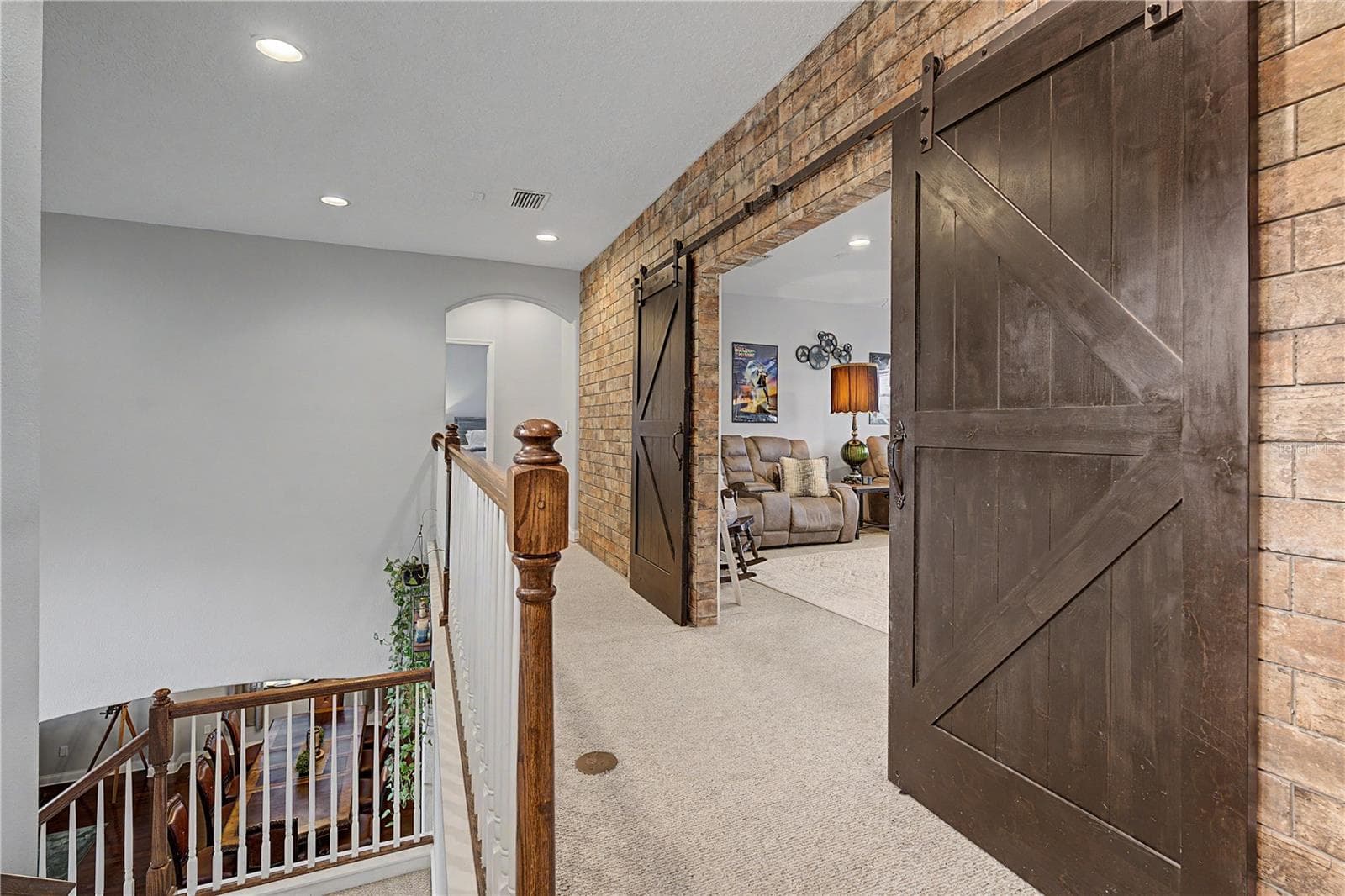 Striking Barn doors open to game room - 3038 MARBLE CREST DR, LAND O LAKES