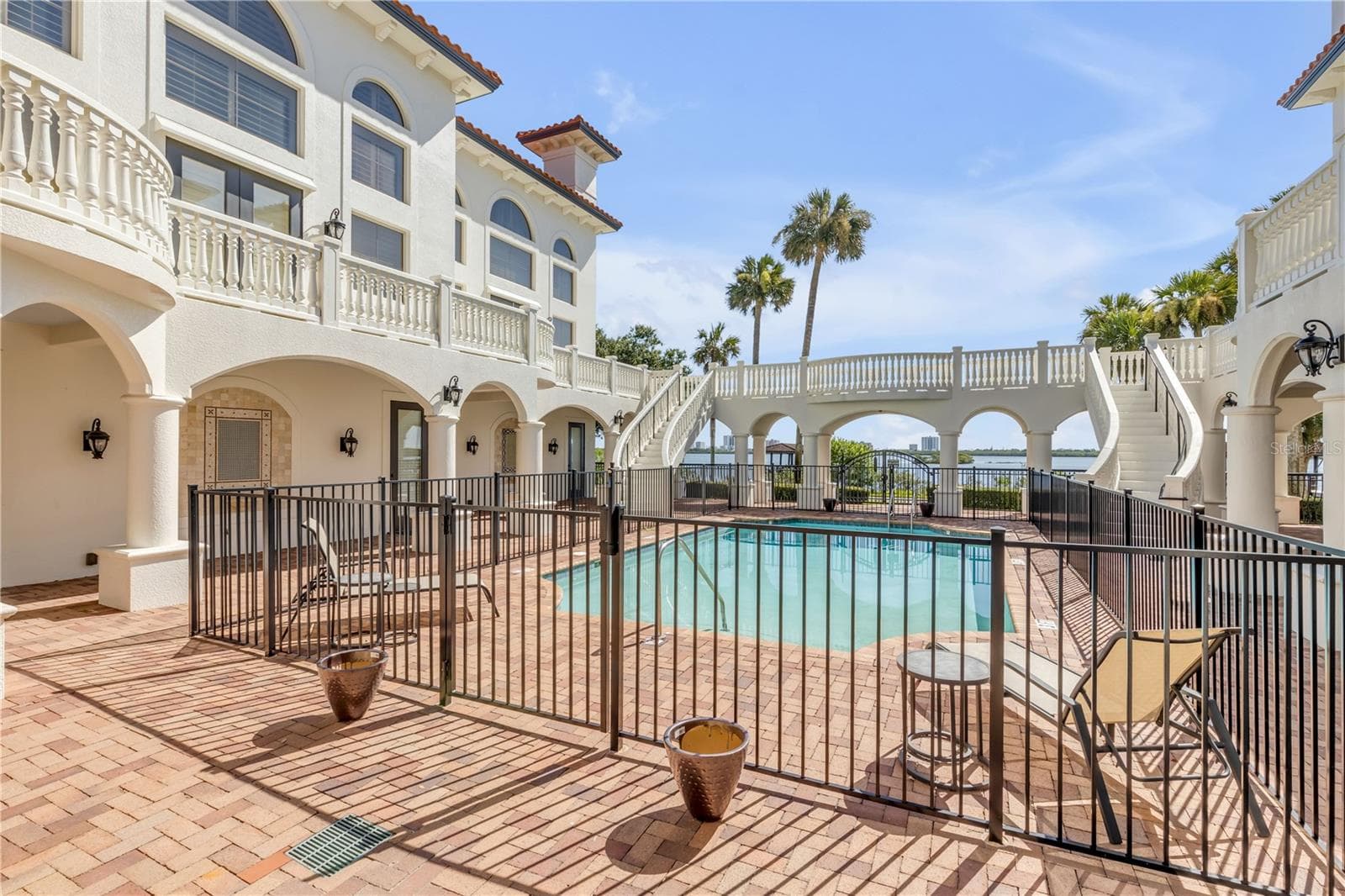 Common Balcony with dual curved staircases coming toward the pool area. - 5090 RIVERSIDE DR #105, PORT ORANGE