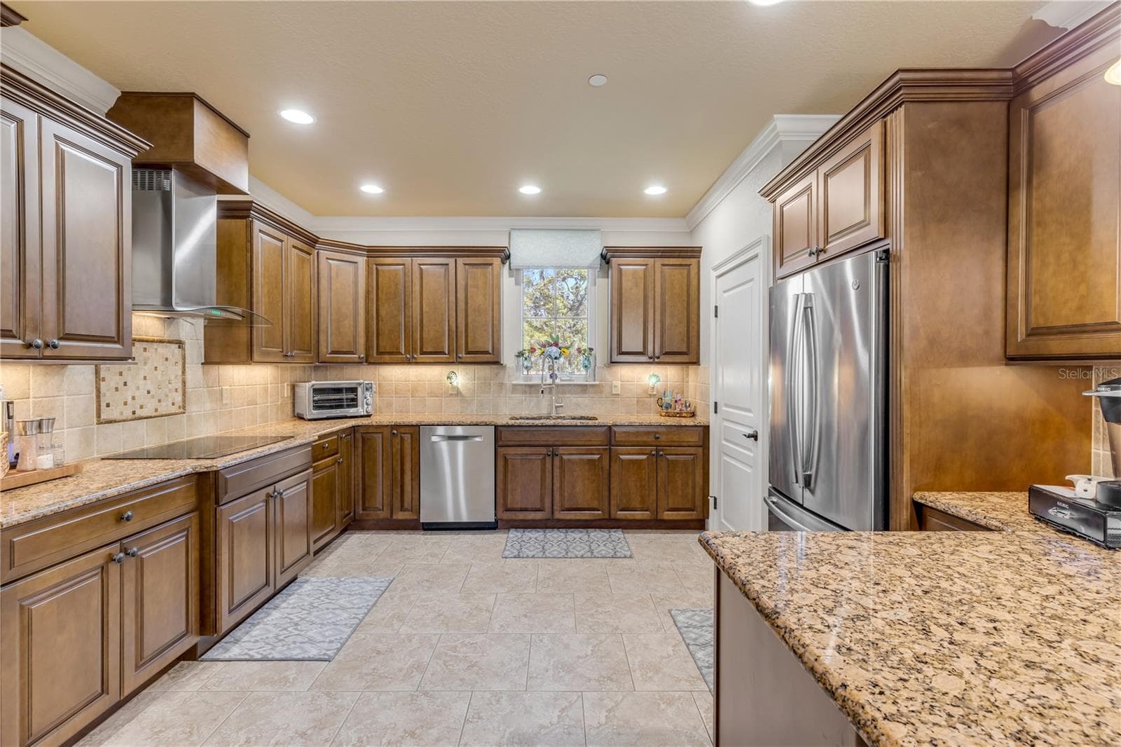 wood cabinets, granite countertops, tile backsplash - 5090 RIVERSIDE DR #105, PORT ORANGE