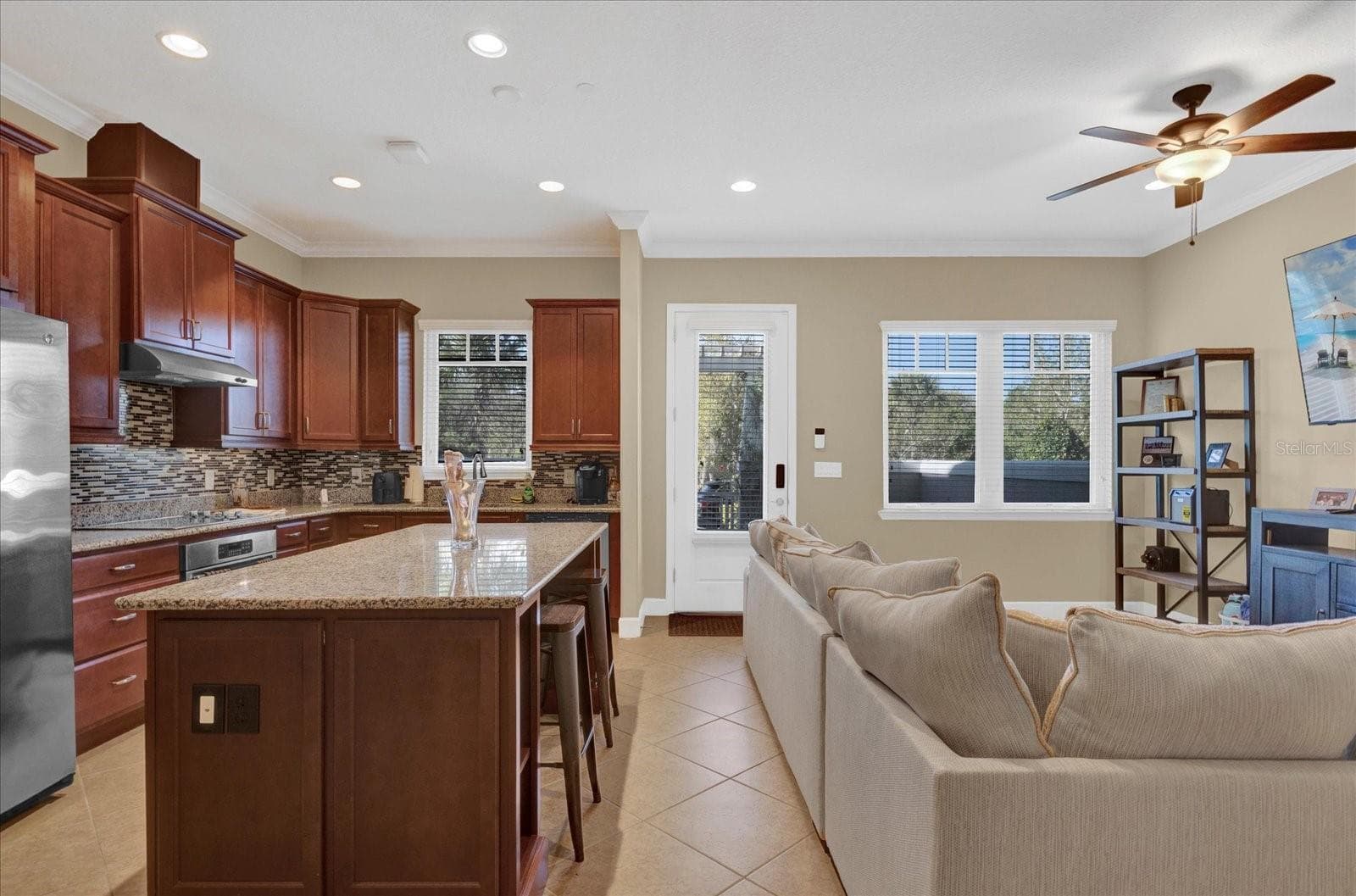 Gourmet kitchen featuring a large center island, granite countertops, and stainless steel appliances. - 9219 LAUREATE BLVD, ORLANDO
