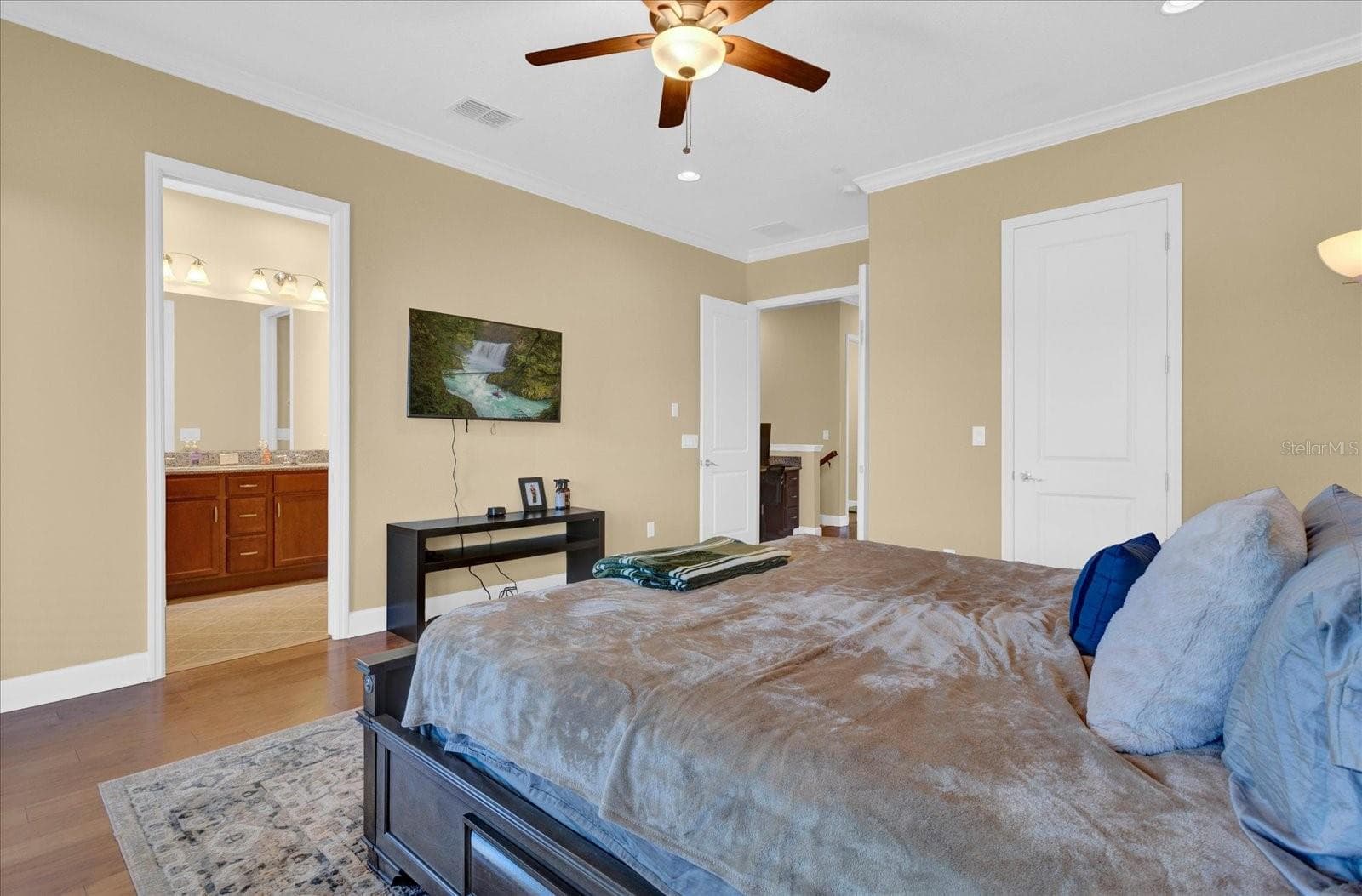Comfortable bedroom retreat with ceiling fan and direct ensuite access. - 9219 LAUREATE BLVD, ORLANDO