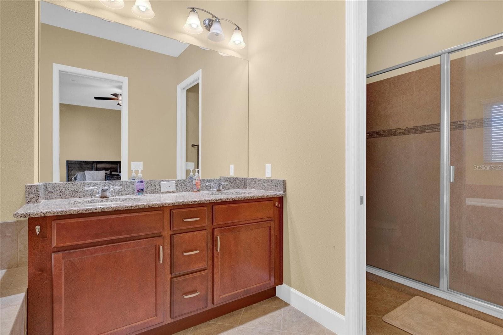 Dual-sink vanity and separate walk-in shower complete the primary bath. - 9219 LAUREATE BLVD, ORLANDO