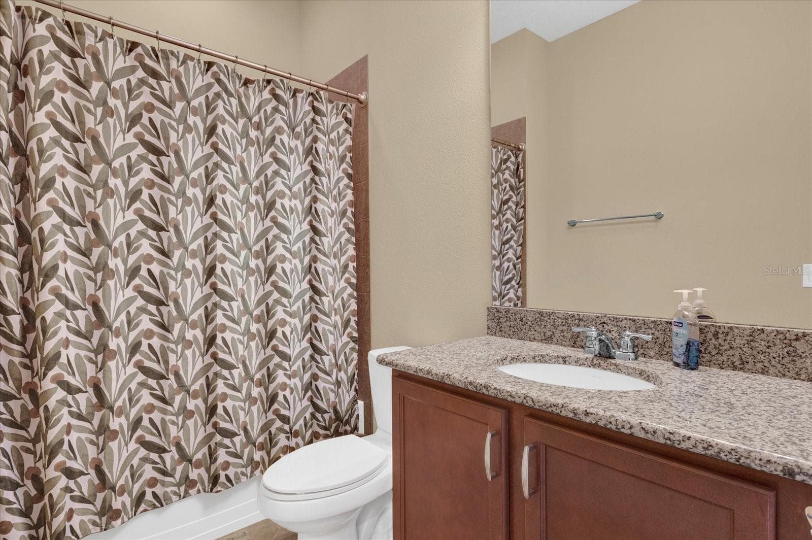 Full guest bathroom with tub/shower combo and vanity storage. - 9219 LAUREATE BLVD, ORLANDO