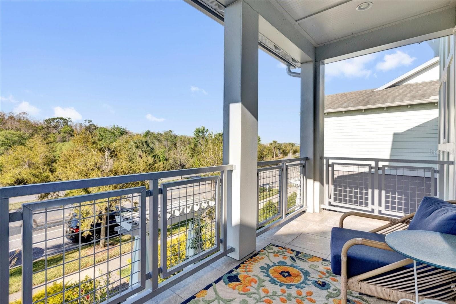 Private covered balcony with seating — a relaxing retreat overlooking the neighborhood. - 9219 LAUREATE BLVD, ORLANDO