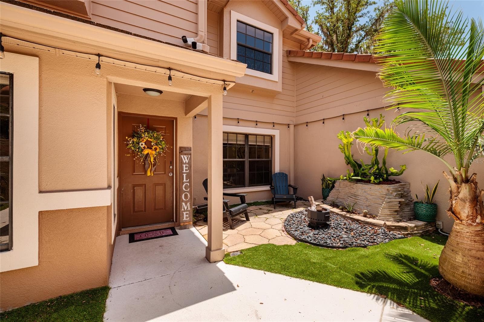 Front with patio, fire pit, and front door - 17557 FAIRMEADOW DR, TAMPA