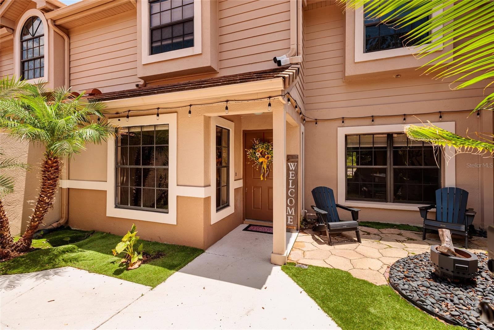 Front with patio, fire pit, and front door - 17557 FAIRMEADOW DR, TAMPA