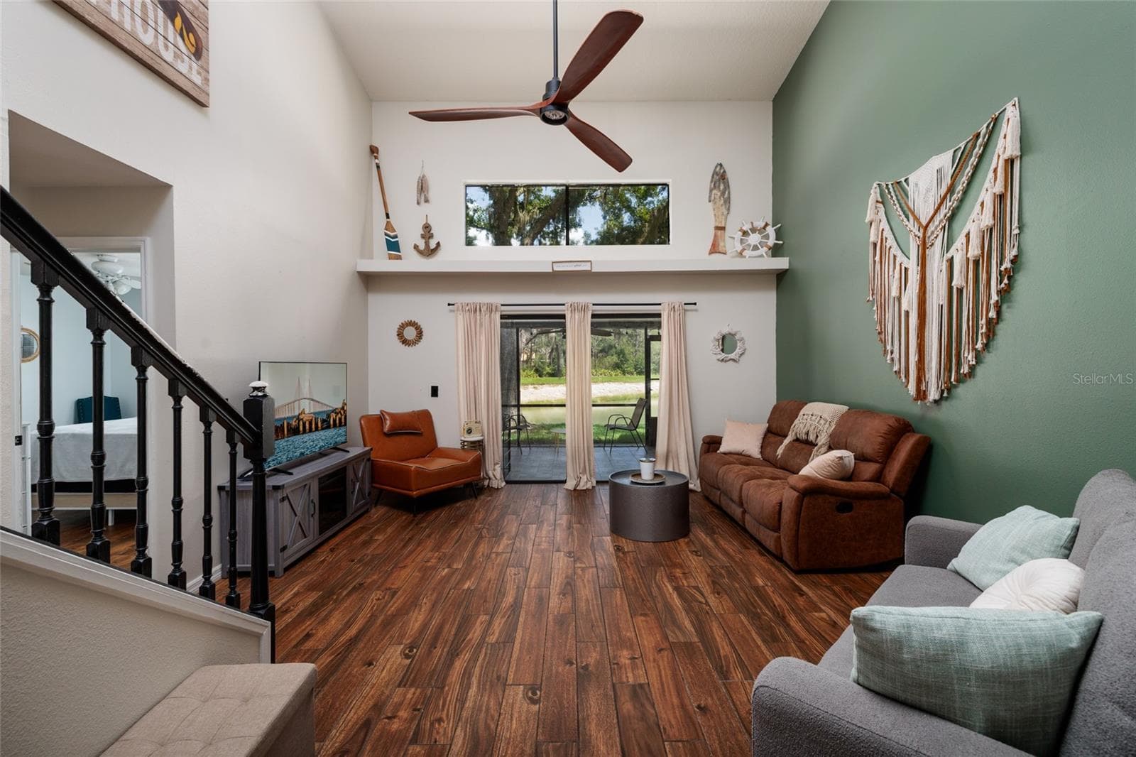 living room with stairs to second floor and view of sliding glass doors - 17557 FAIRMEADOW DR, TAMPA