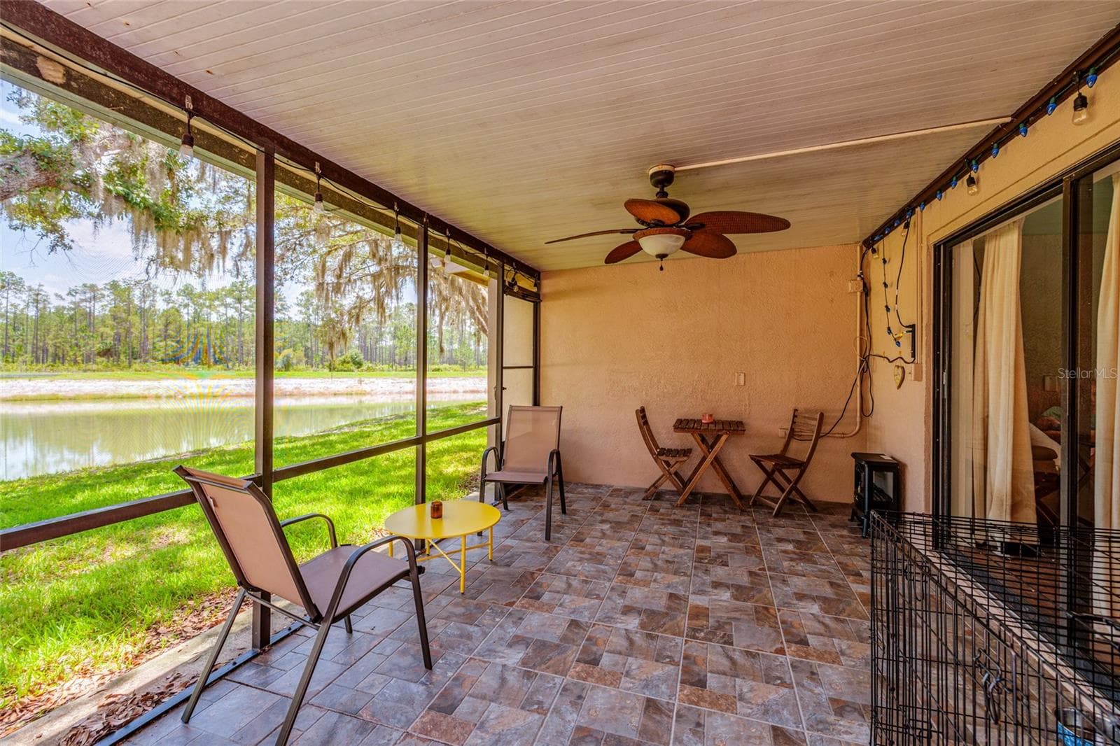 screened in porch with lake view - 17557 FAIRMEADOW DR, TAMPA