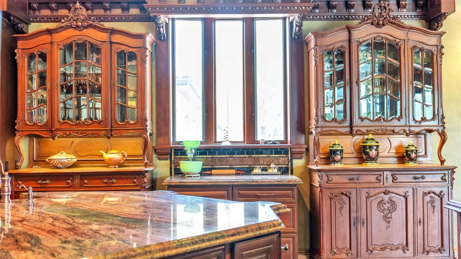 Anchored by Twin Antique Hutches, the kitchen features stately Symmetrical millwork, Exotic Solarious Natural Stone Island. Every slab features dramatic swirling veins, creating a living piece of art across the counters. - 5503 DOWNING ST, DOVER