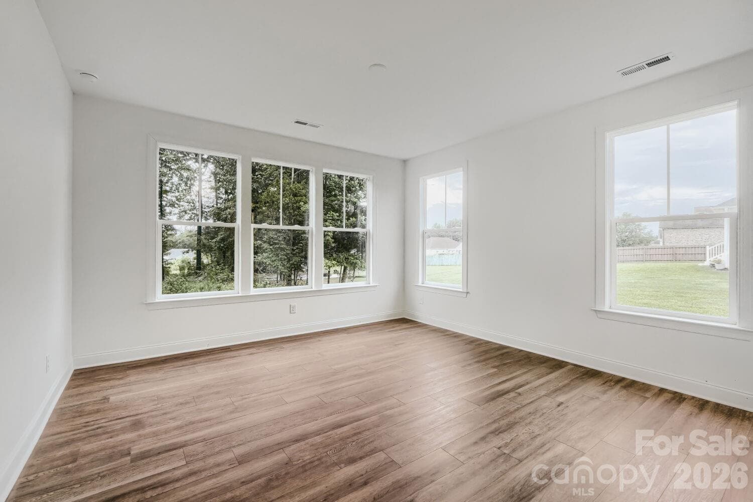 A spacious primary suite with tripe windows overlooking the back yard and a private ensuite bath. - 2358 Fay Jones Road, Denver