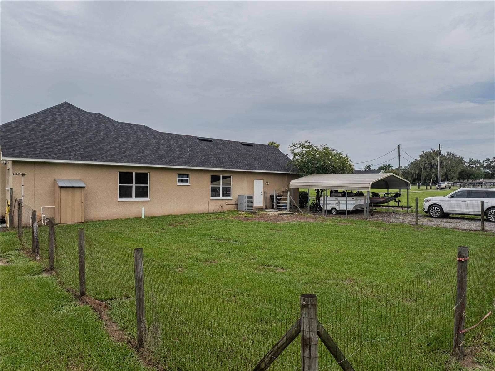 Side view of garage entrance and 2 car carport and a small fenced area - 4280 TURNER RD, MULBERRY