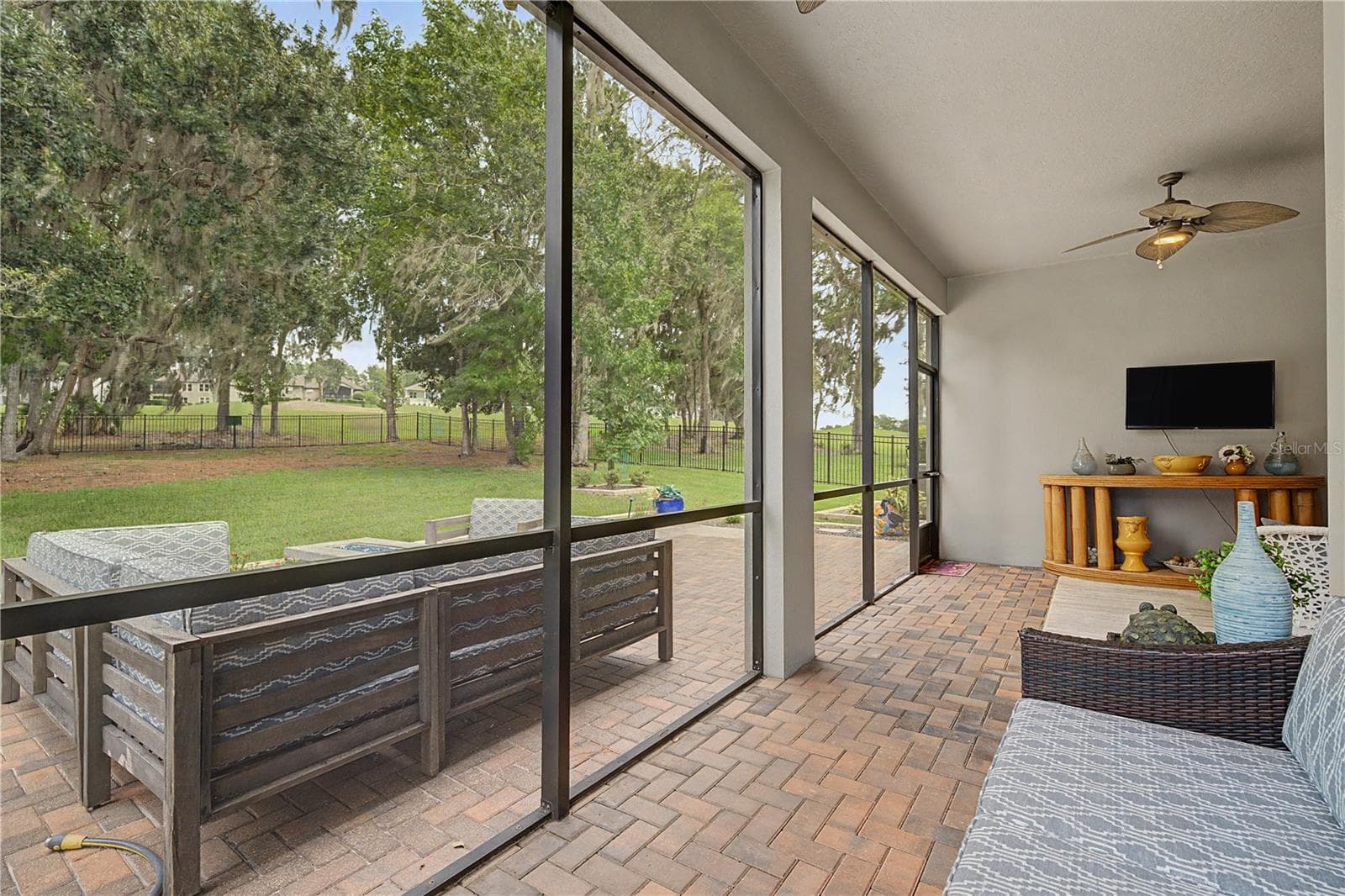 Screened lanai under roof with open patio and fenced yard beyond - 4926 SOUTHERN VALLEY LOOP, BROOKSVILLE