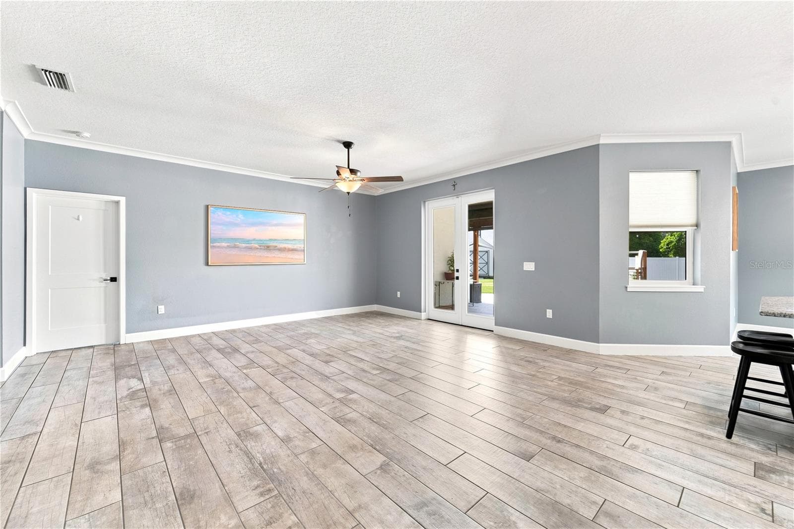 Living Room leading to the primary bedroom and exterior portion of the home. - 125 LONGWOOD DR, OSTEEN