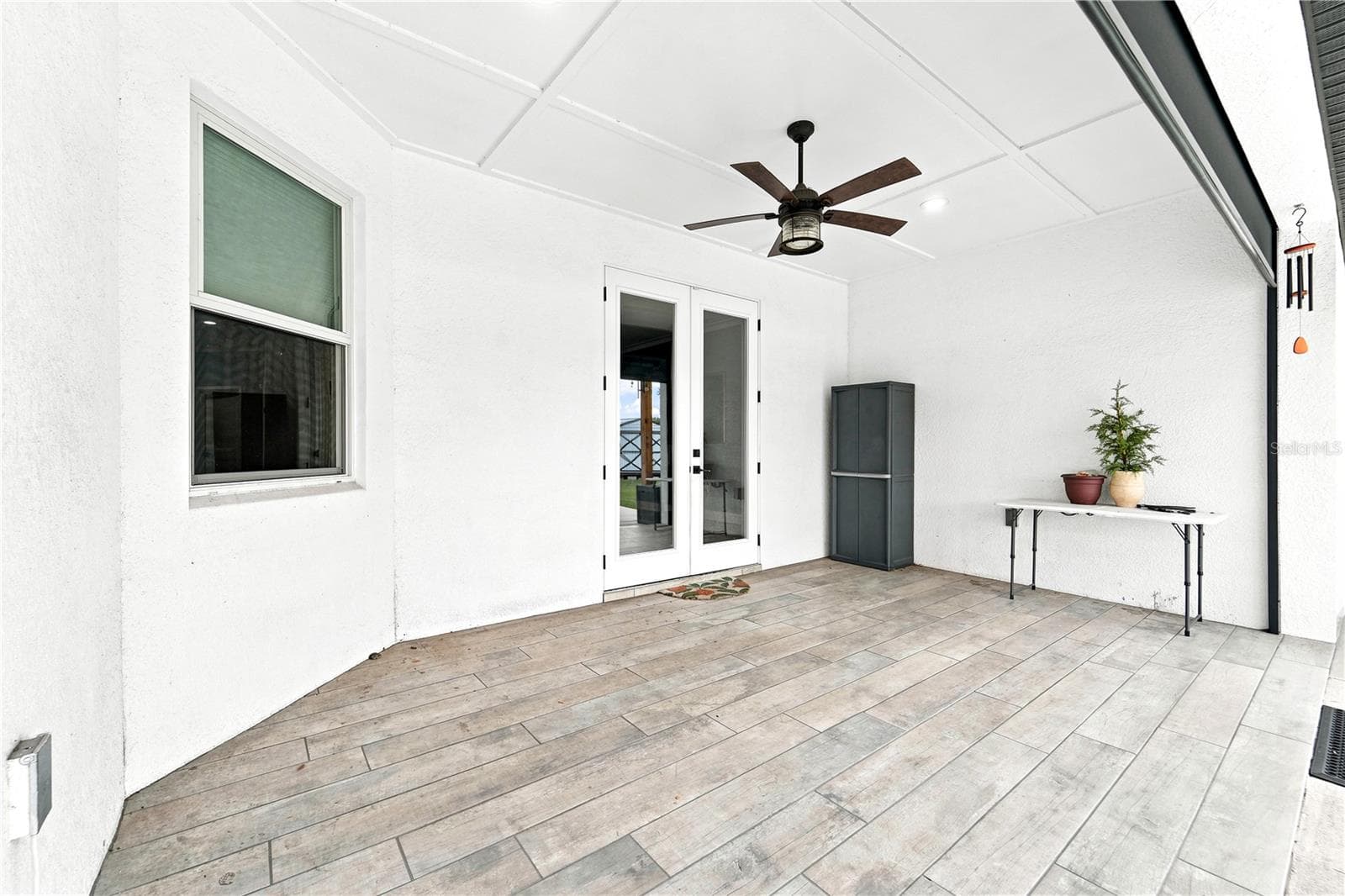 Covered lanai leading back into the home. - 125 LONGWOOD DR, OSTEEN