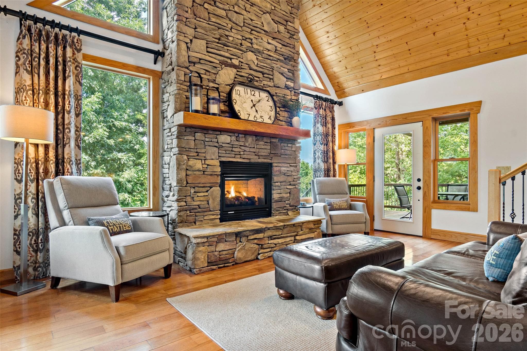 This stately living room features a gas log fireplace and an abundance of natural light. - 179 Rock Spring Road, Lake Lure