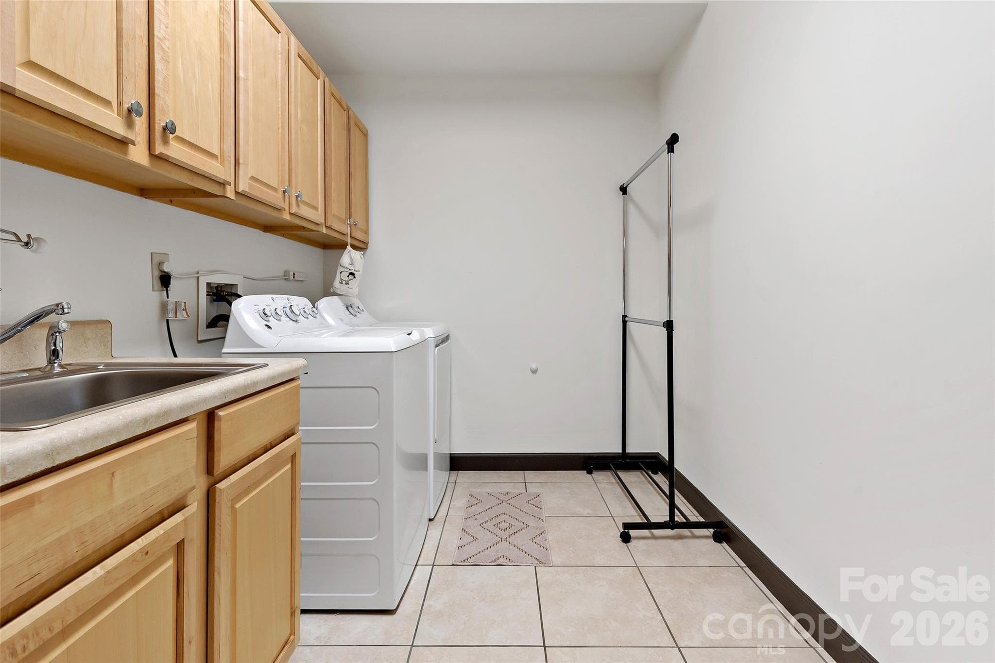 Spacious laundry room with upper and lower cabinets and a utility sink. - 179 Rock Spring Road, Lake Lure