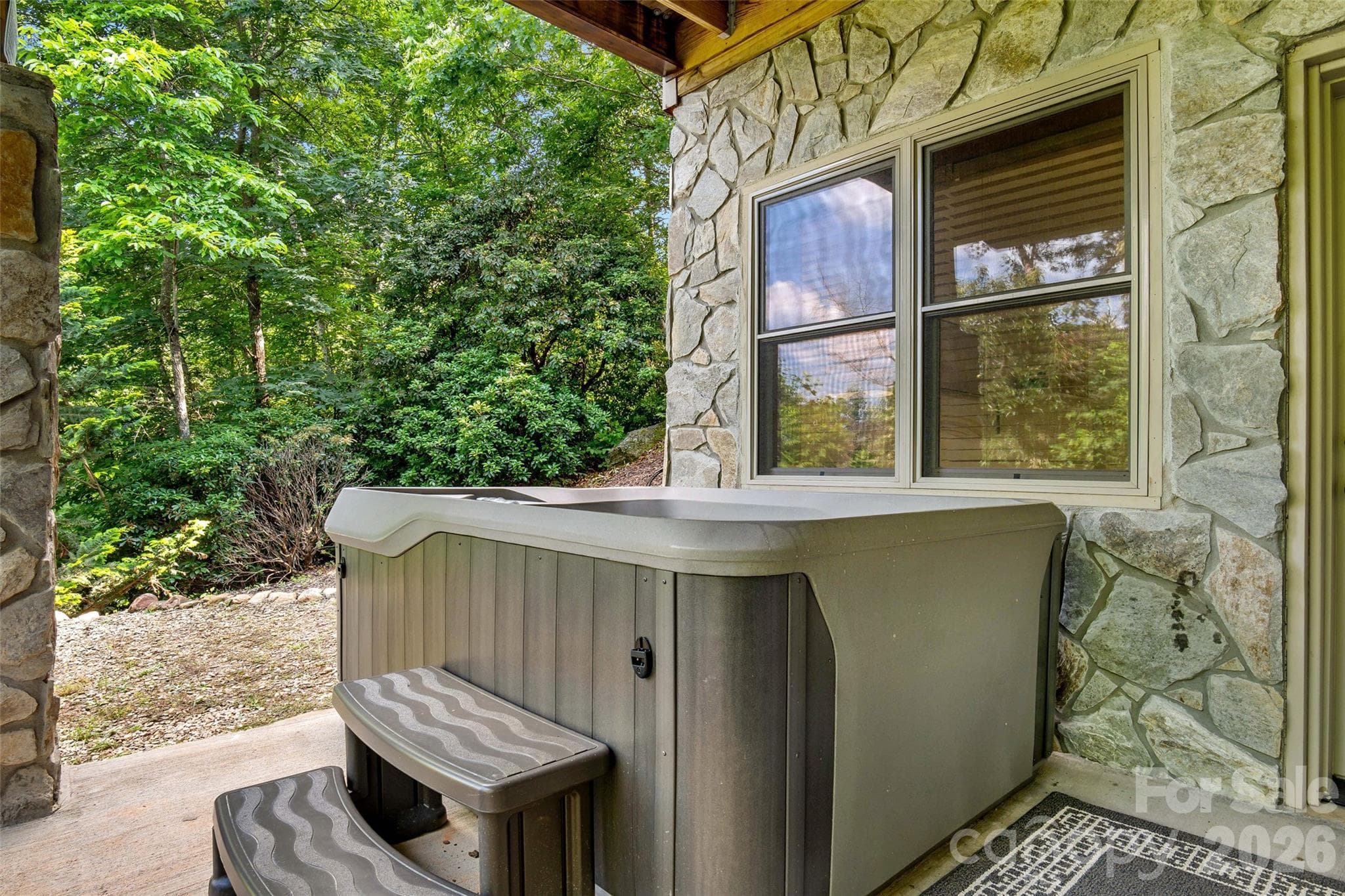 Unwind in the hot tub overlooking the fire pit and outdoor gathering area. - 179 Rock Spring Road, Lake Lure