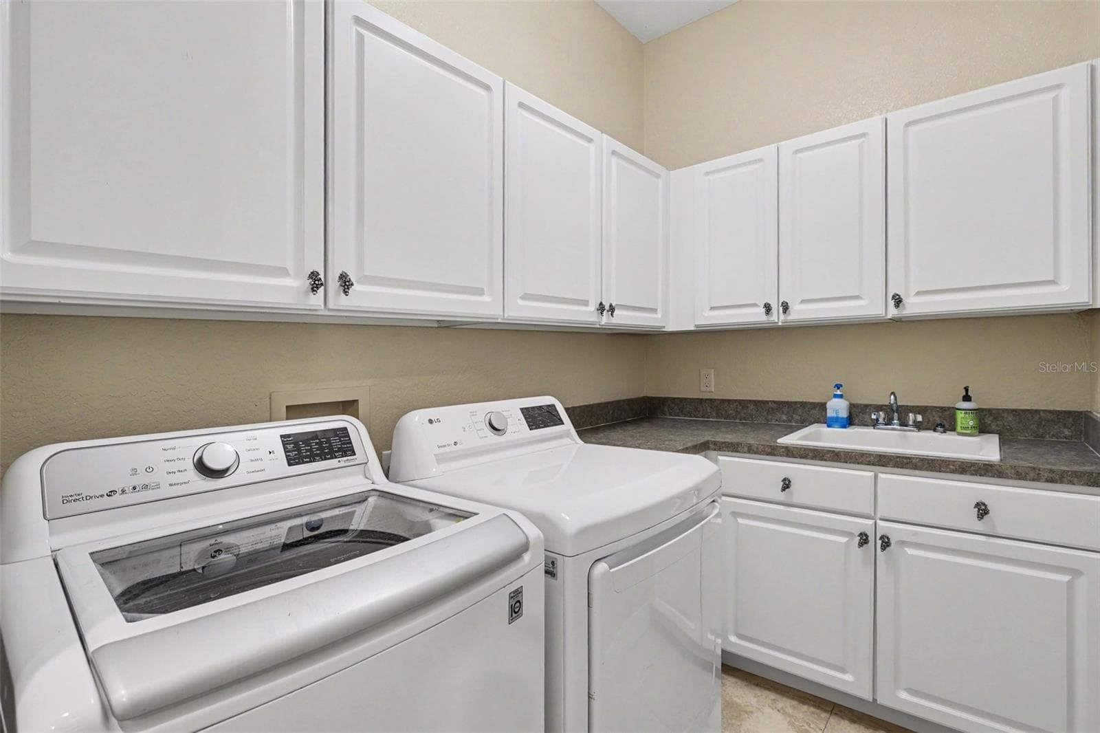 Laundry room has built in cabinets and sink - 2912 HAMPTON PLACE CT, PLANT CITY