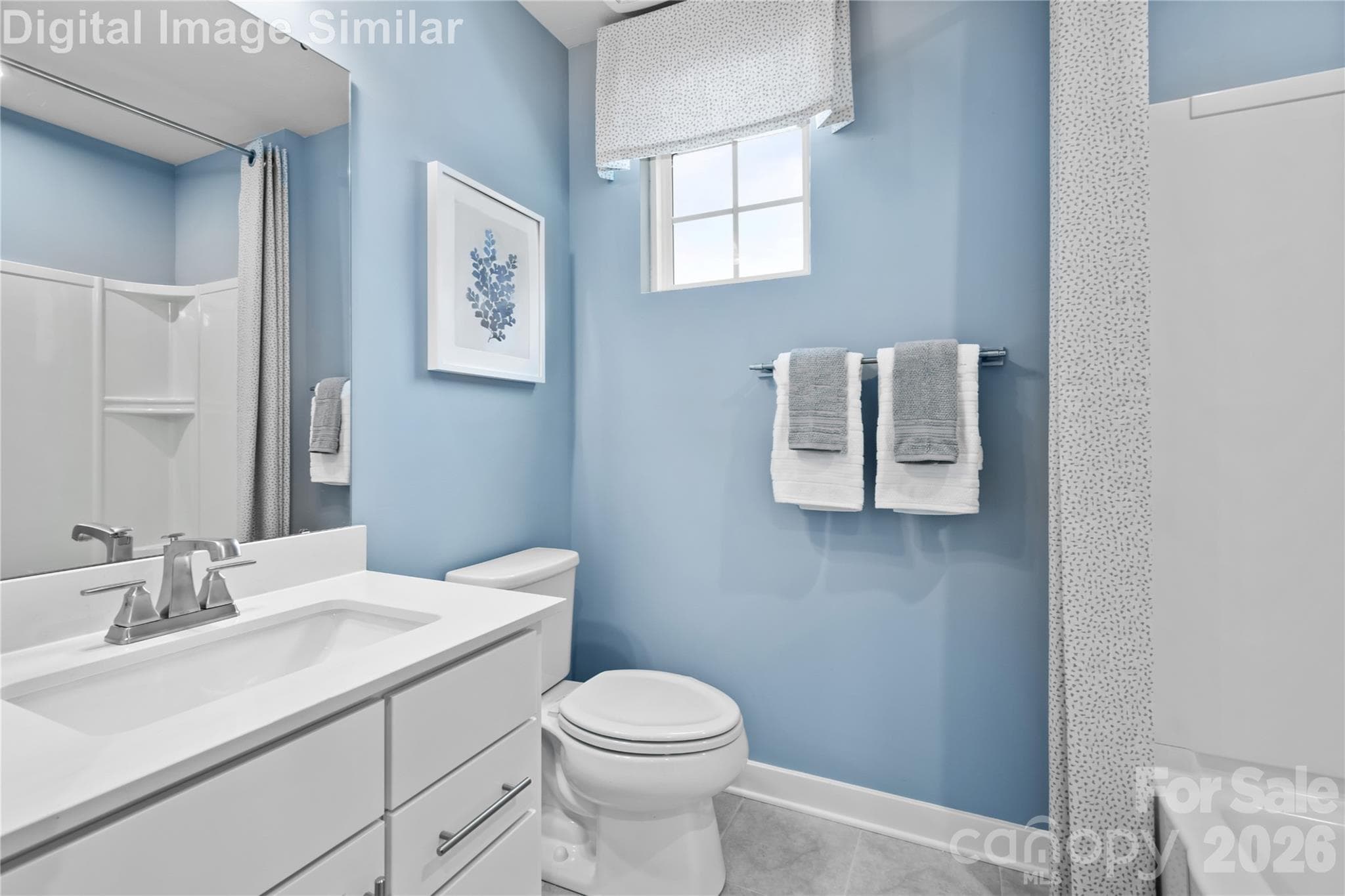 Bright shared bathroom with a sunlit window, full-size tub, and a large mirror—blending function and style for everyday comfort. - 11194 Emerson Landing Drive, Charlotte