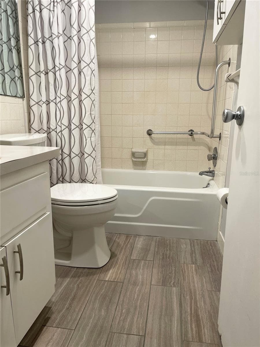 Bathroom with updated flooring and helpful access bars - 5880 38TH AVE N #206, ST PETERSBURG