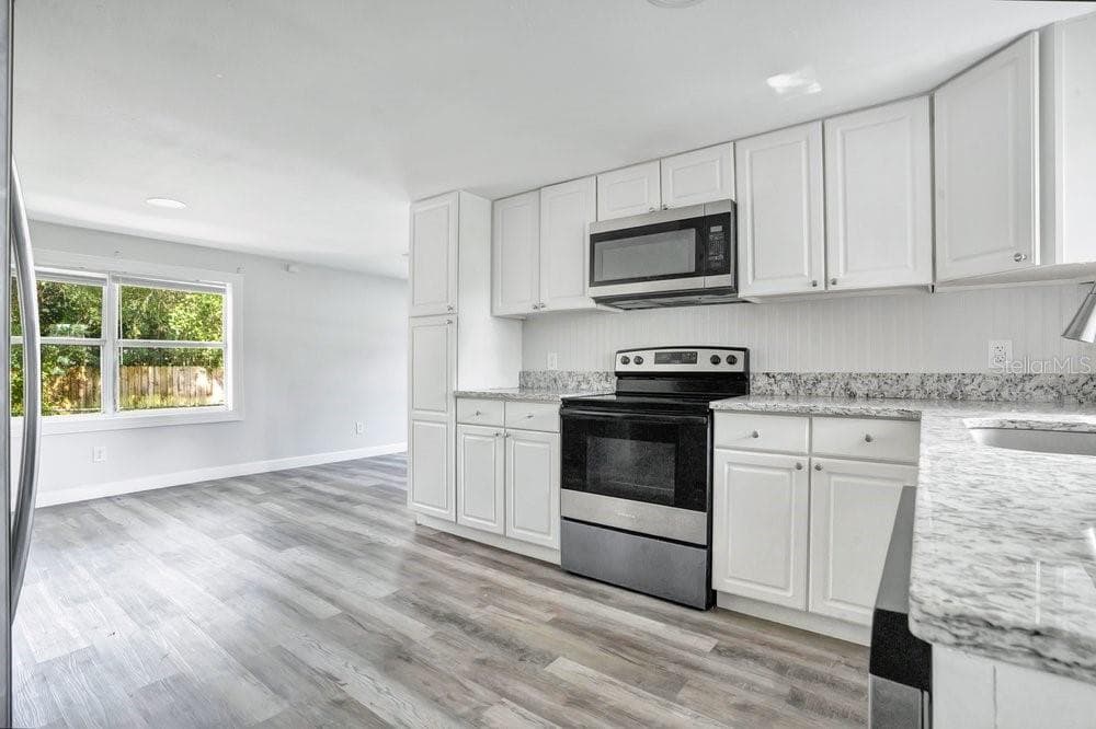 Updated kitchen flows into a dining area and the living room beyond. - 2012 E HARDING ST, ORLANDO