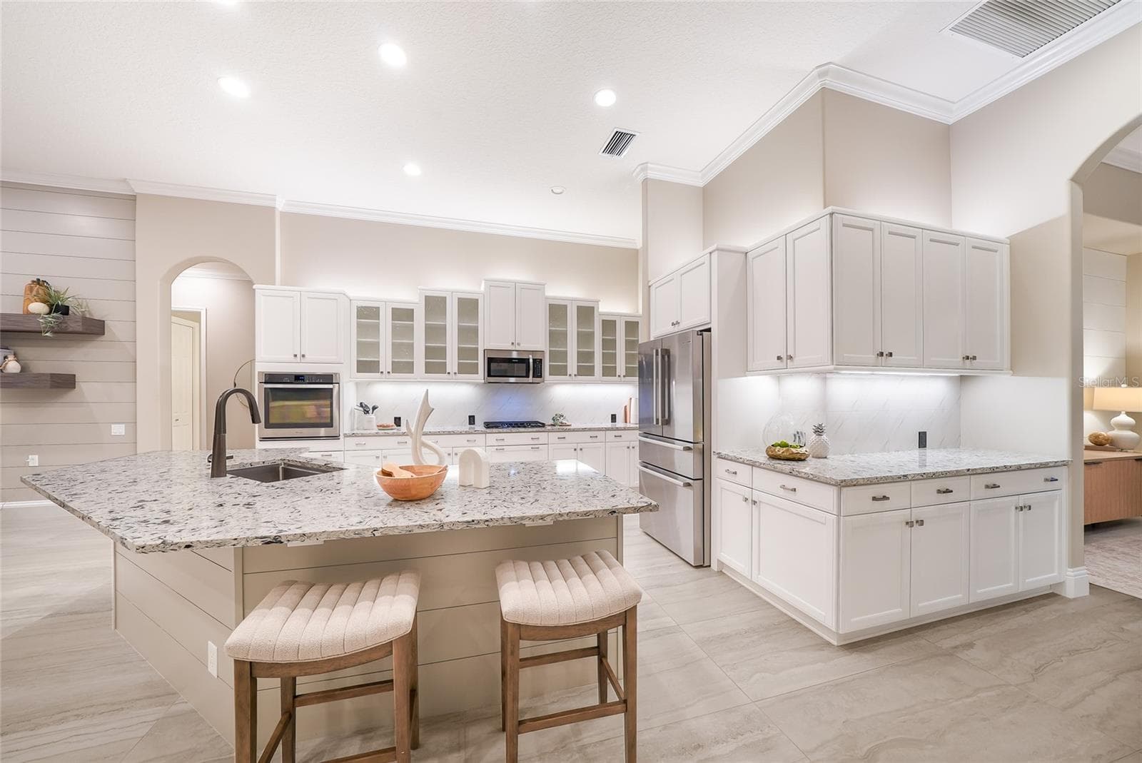 Updated gourmet kitchen with stainless steel appliances, sprawling counter height stone counters, wood cabinetry, large and customized walk-in pantry - 8122 LONE TREE GLN, LAKEWOOD RANCH