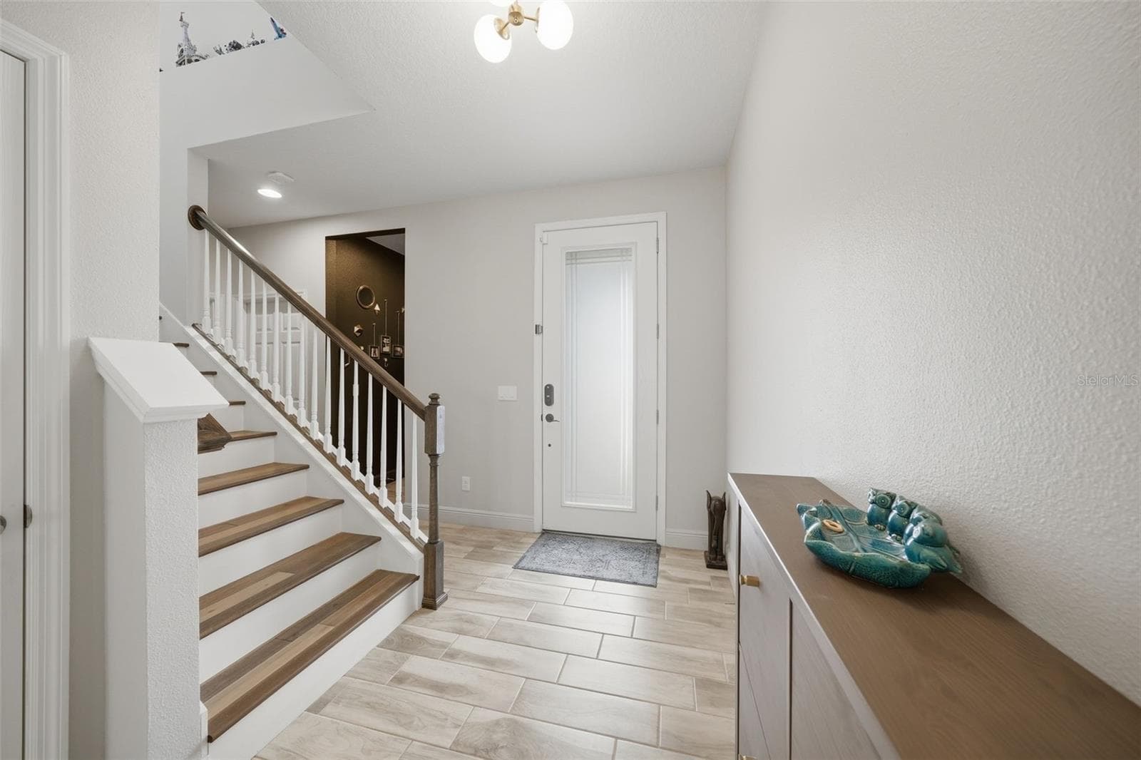 The inviting foyer features a beautiful staircase, adding architectural charm and a dramatic entrance to the home. - 4801 BALLANTRAE BLVD, LAND O LAKES