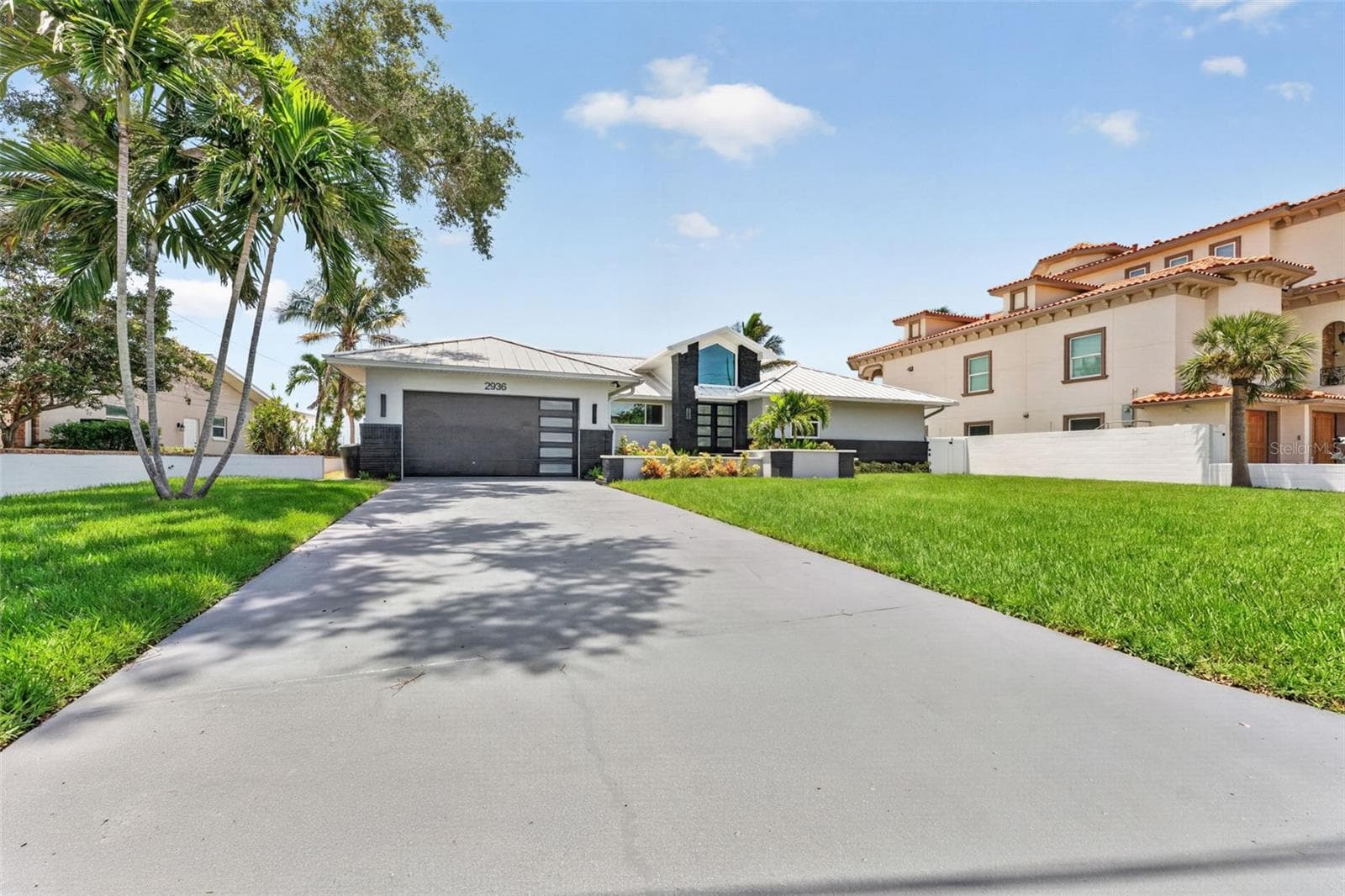 Spacious parking pad just painted & re-sealed with plenty of room for guests, boats, or an RV. - 2936 68TH AVE S, ST PETERSBURG