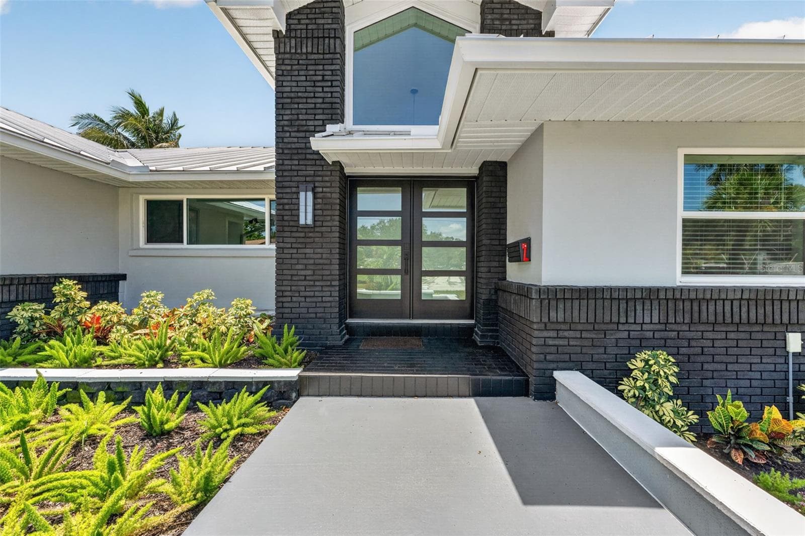 Modern double glass doors create a grand and inviting entry with a sleek, contemporary touch. - 2936 68TH AVE S, ST PETERSBURG