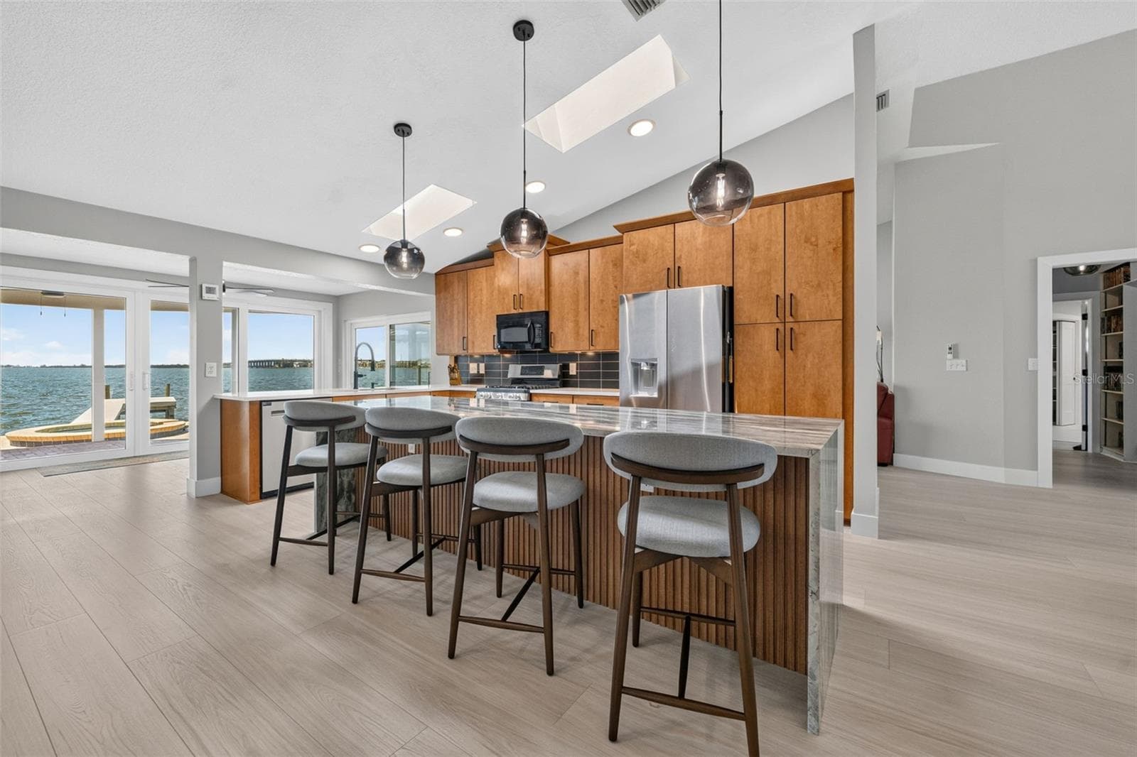 Bar seating at kitchen island with sleek pendant lighting - 2936 68TH AVE S, ST PETERSBURG