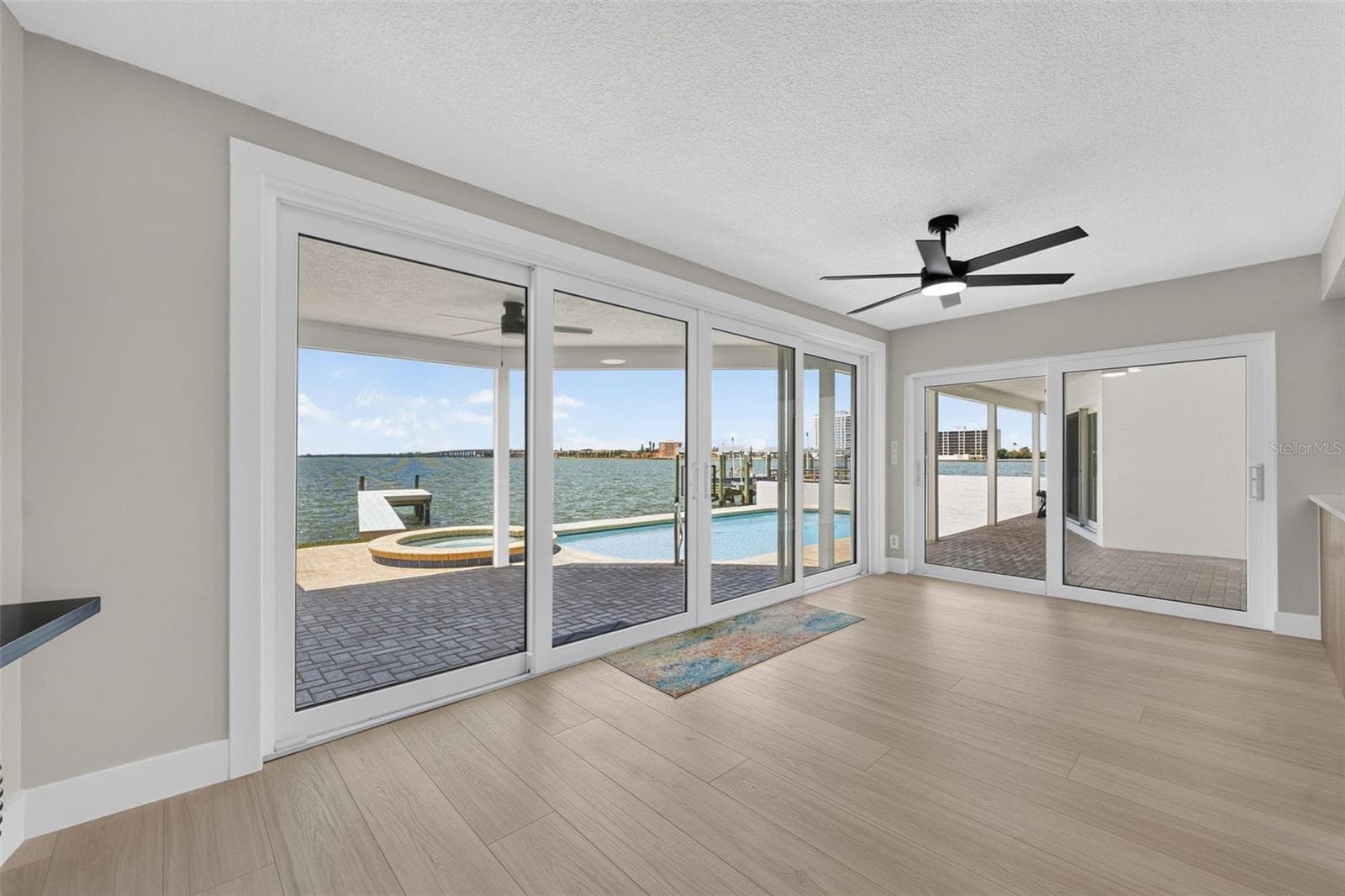 Bright breakfast nook/bonus room with impact-rated sliding glass doors opens to the pool deck and stunning waterfront views. - 2936 68TH AVE S, ST PETERSBURG