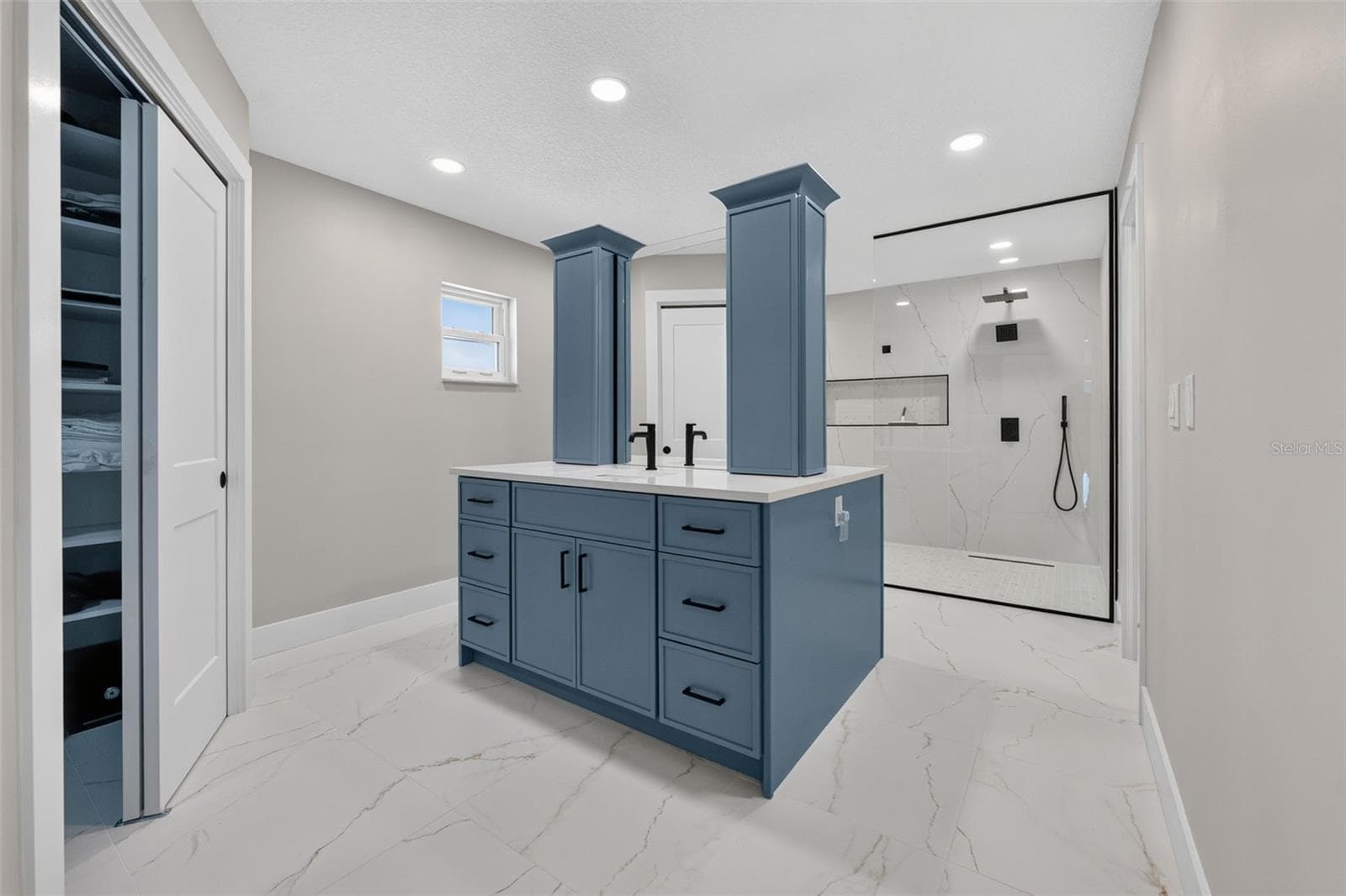 Stunning primary bath featuring custom blue dual vanities - 2936 68TH AVE S, ST PETERSBURG