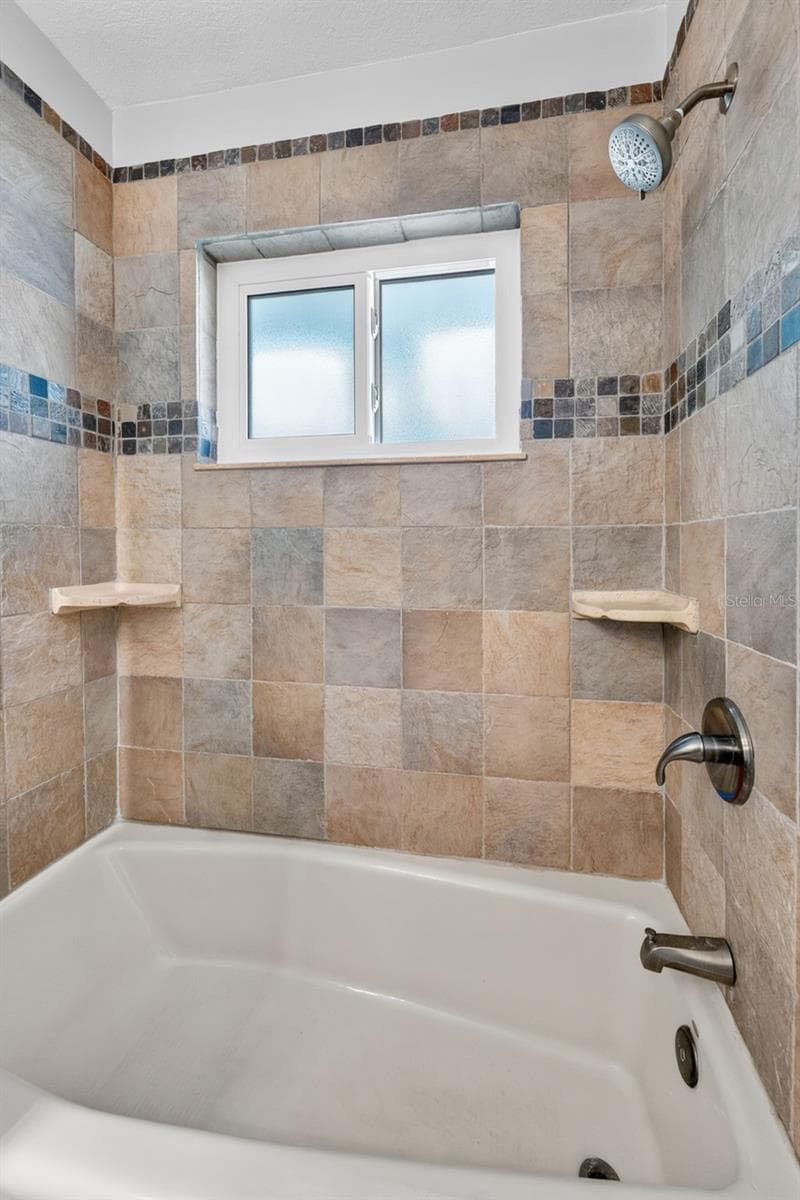 Hall bathroom with a convenient tub/shower combo, combining functionality and style. - 2936 68TH AVE S, ST PETERSBURG