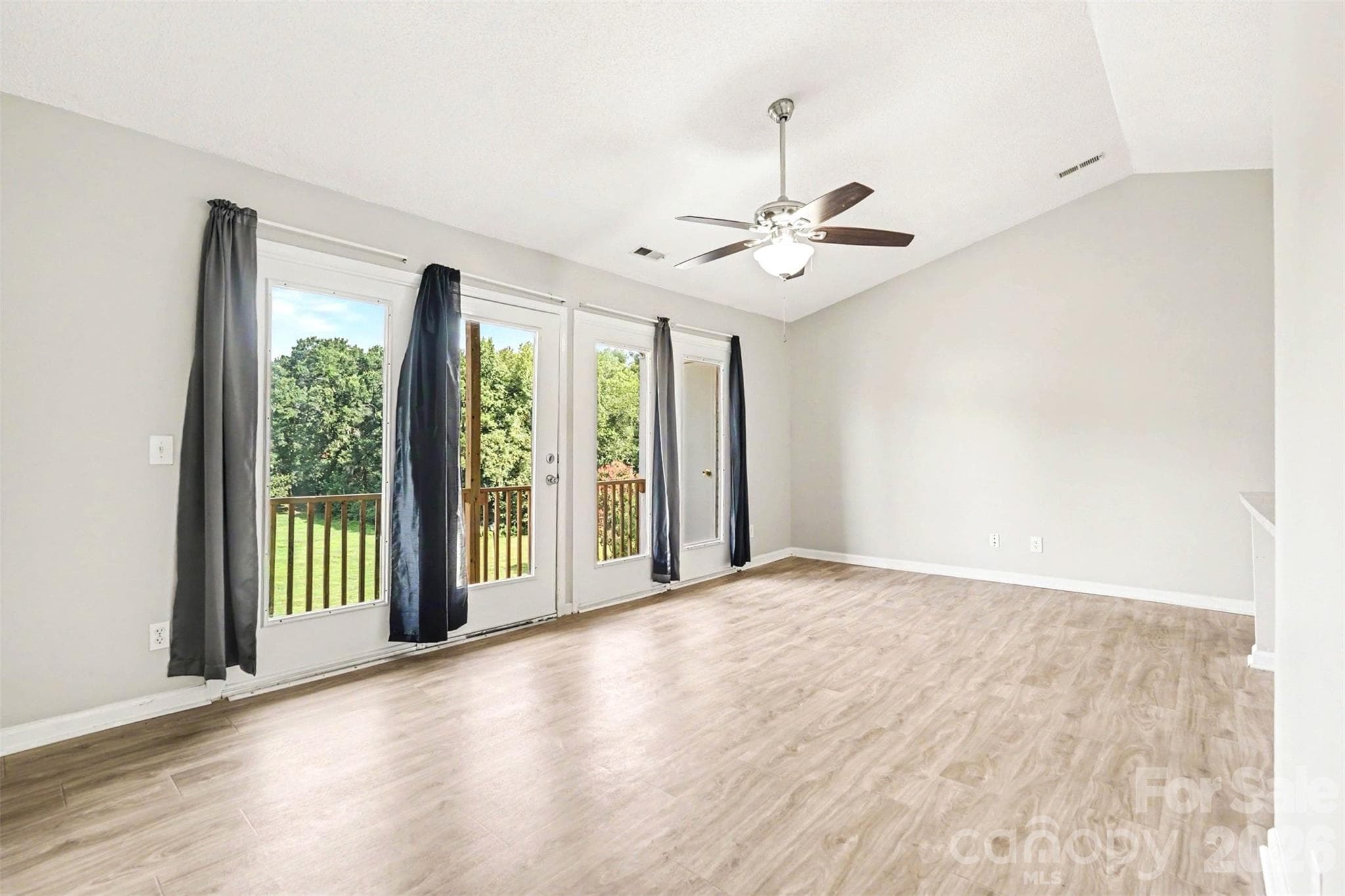 The living room features lots of natural light and a ceiling fan. - 6165 Meadow Rose Lane, Charlotte