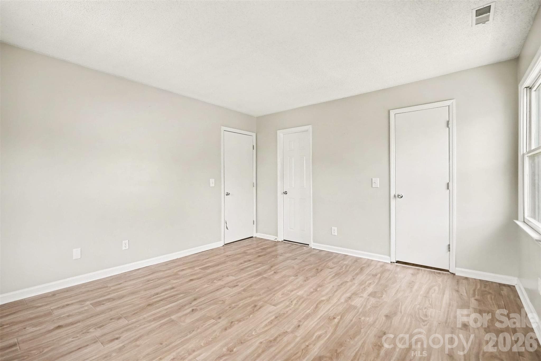 Primary bedroom...one door leads to the primary bath, the other to the large walk-in closet. - 6165 Meadow Rose Lane, Charlotte