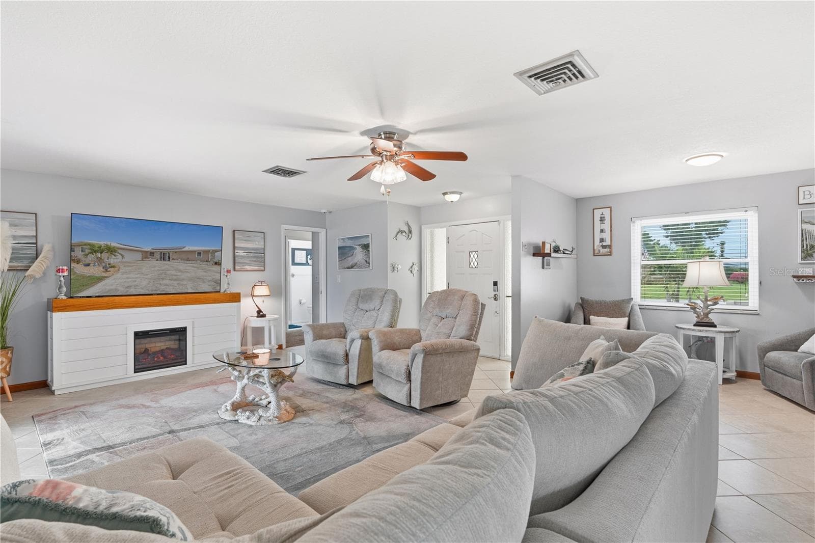 Inviting Living Room with Electric Fireplace and Seamless Patio Access - 2284 BROAD RANCH DR, PORT CHARLOTTE