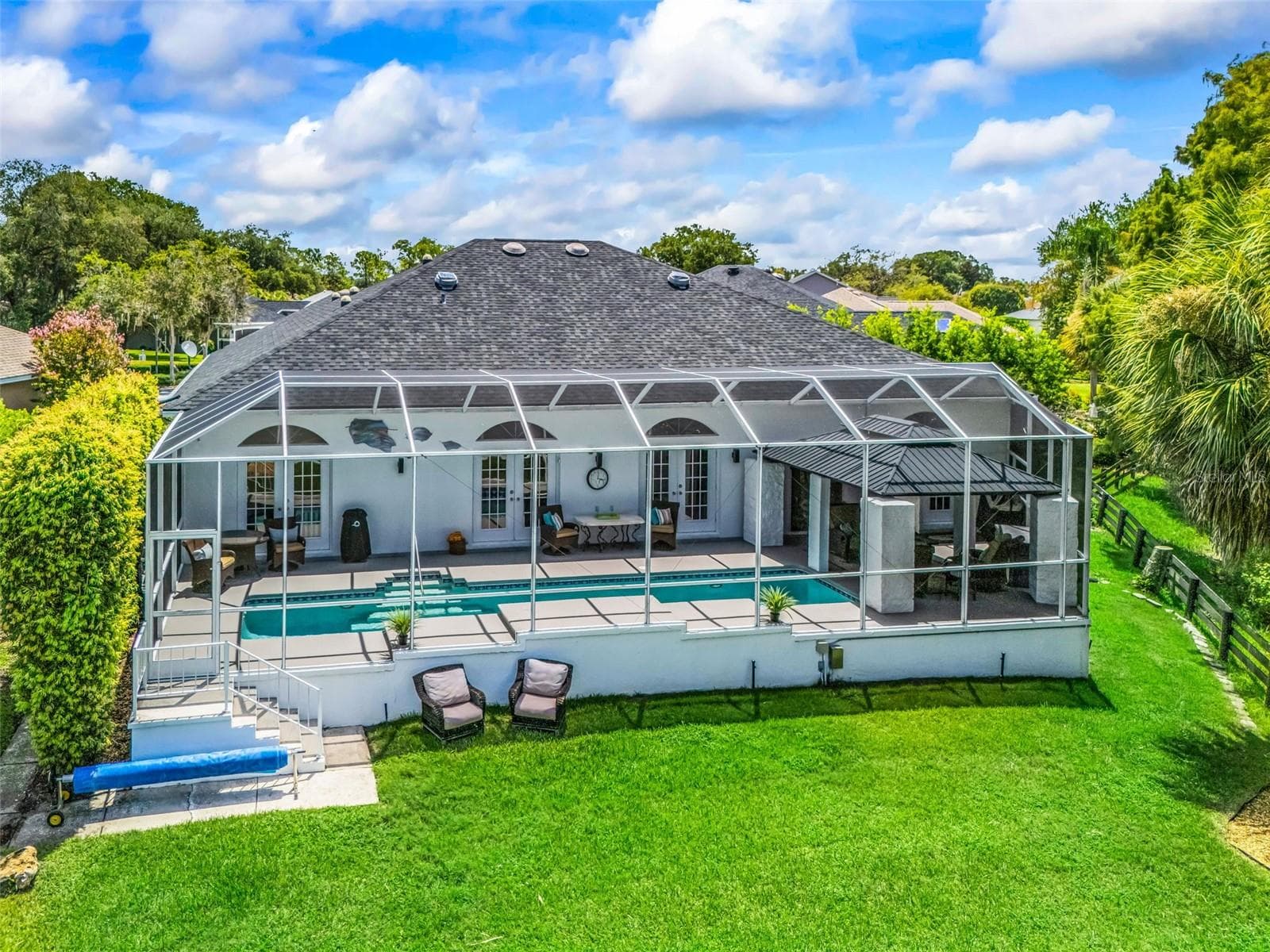 Resort-style outdoor living features a large screened pool and spacious pool deck, creating an inviting setting for relaxing, entertaining, and enjoying the Florida lifestyle. - 714 CIMARRON AVE, THE VILLAGES