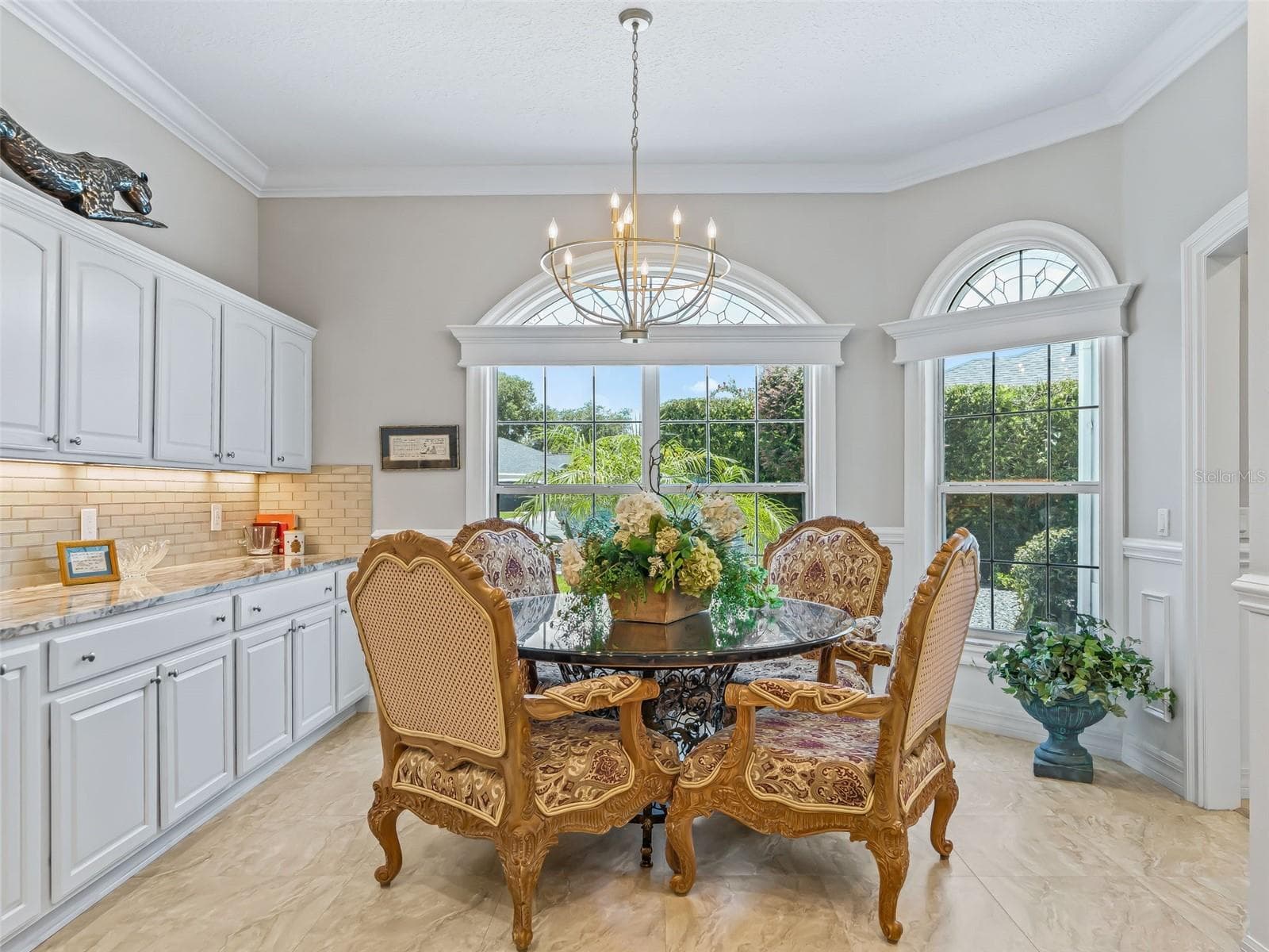 Elegant dining space is surrounded by dramatic windows offering abundant natural light plus inviting views of in-coming guests and the front of the property - 714 CIMARRON AVE, THE VILLAGES