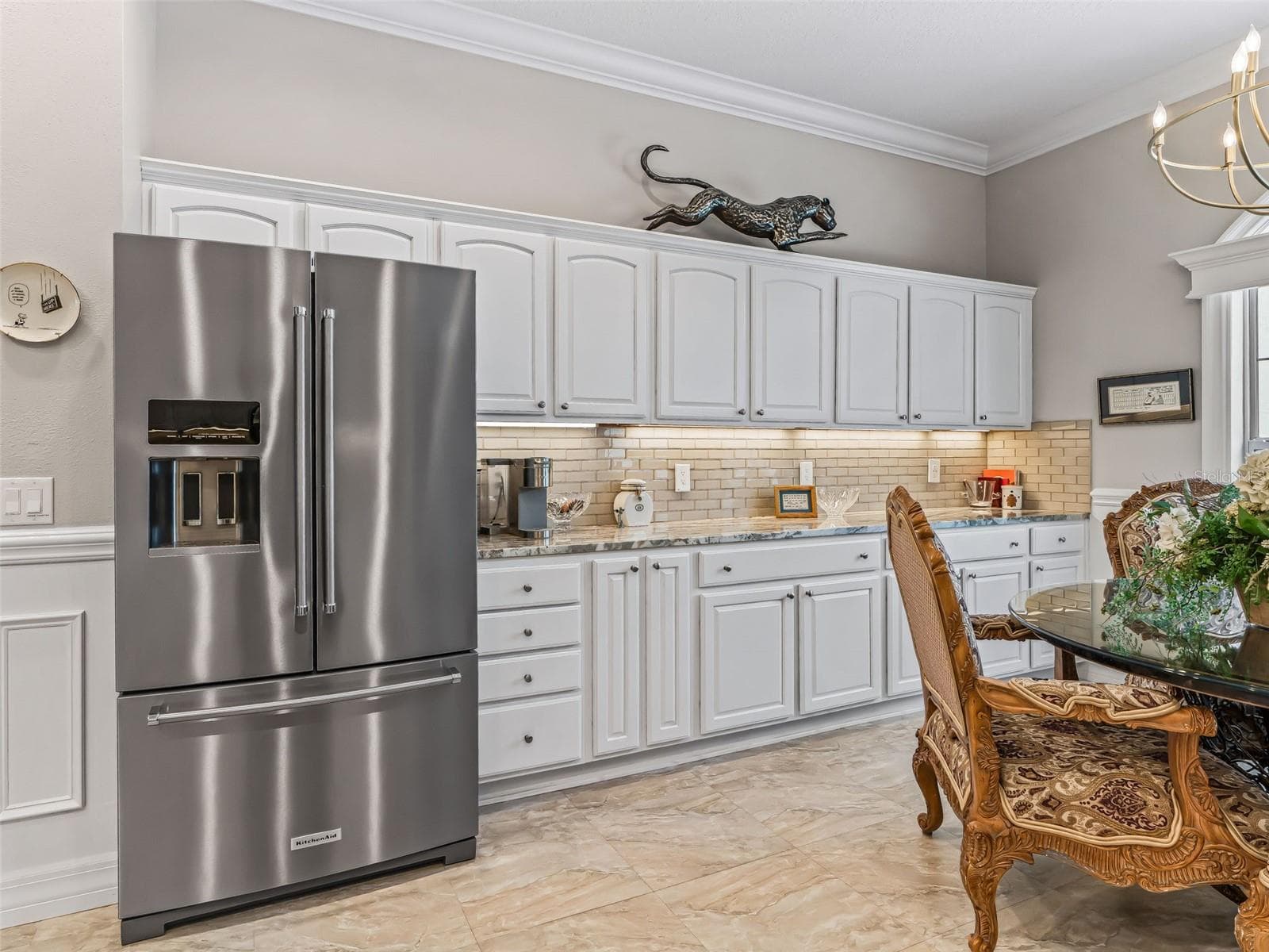 Beautiful white cabinetry provides exceptional storage throughout the kitchen, complemented by granite countertops, stainless steel appliances, and a neutral tile backsplash. - 714 CIMARRON AVE, THE VILLAGES