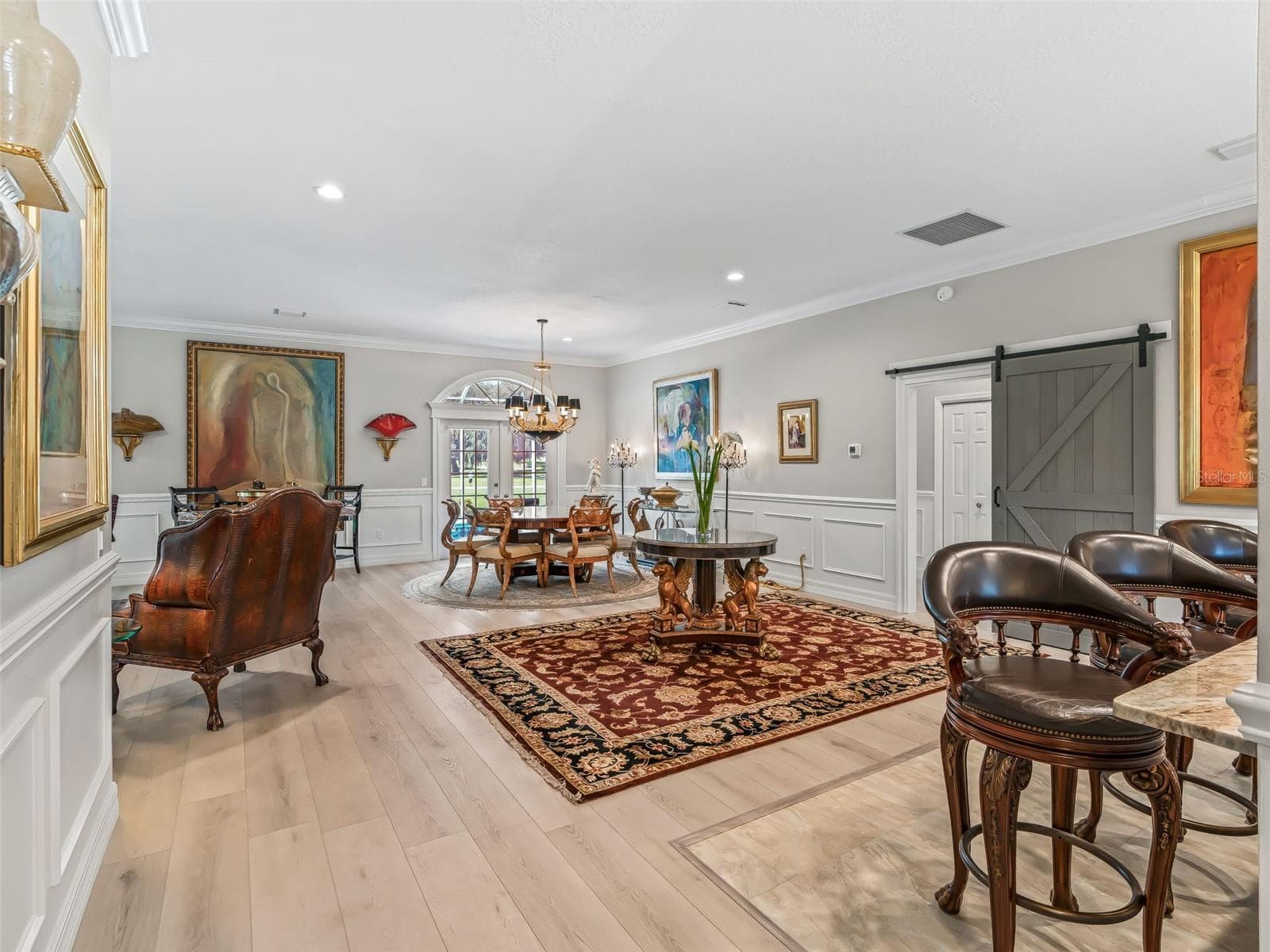 Another view of the spacious main living area highlights the seamless flow between dining, entertaining, and kitchen spaces, all enhanced by high-end finishes and custom trim details. - 714 CIMARRON AVE, THE VILLAGES