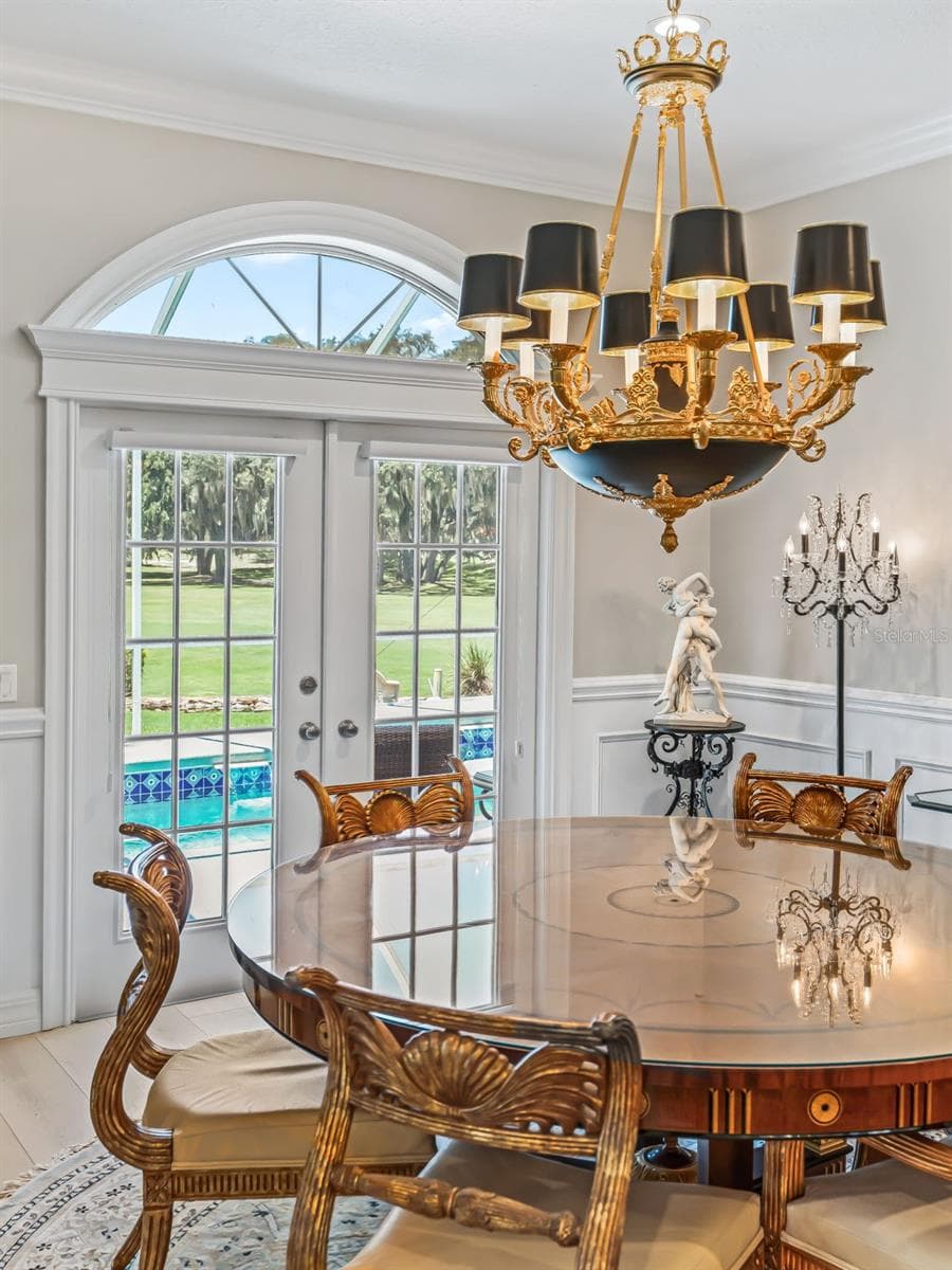 Natural light pours through the large arched window, creating a bright and inviting dining space accented by upgraded lighting and refined architectural details. - 714 CIMARRON AVE, THE VILLAGES