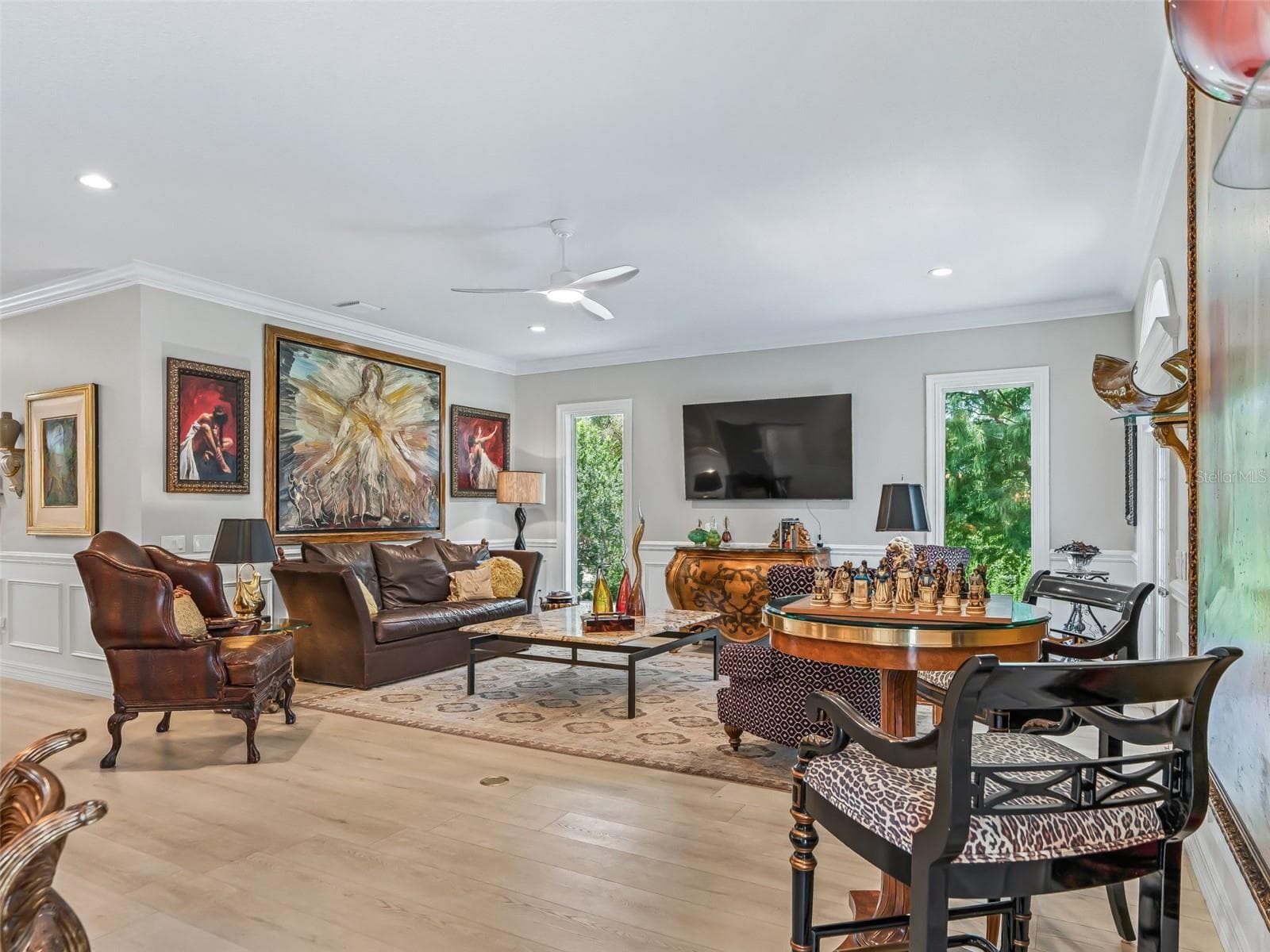 The expansive 19.8'x16.3' living room offers plenty of room for multiple seating areas and is enhanced by luxury vinyl plank flooring, crown molding, upgraded fan, and large picture windows displaying the beautiful PRESERVE VIEW! - 714 CIMARRON AVE, THE VILLAGES