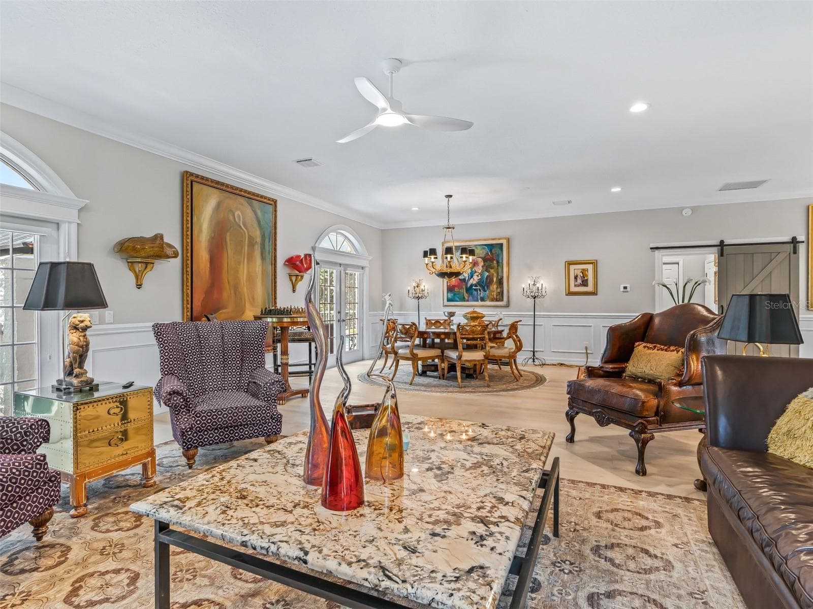 Another wide-angle view of the main living area highlights the generous proportions, luxury vinyl plank flooring, recessed lighting, upgraded ceiling fans, and easy flow into the dining and kitchen spaces. - 714 CIMARRON AVE, THE VILLAGES
