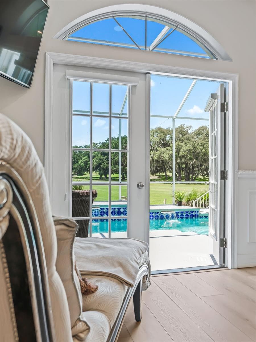 French doors provide direct access from the primary bedroom to the screened lanai and heated lap pool, allowing beautiful outdoor views and Florida sunshine to become part of the suite. - 714 CIMARRON AVE, THE VILLAGES