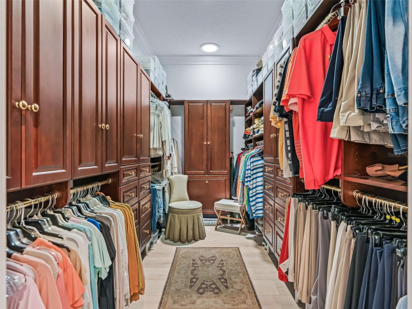 A closer look at the expansive primary closet highlights the rich cherry wood cabinetry and extensive custom storage designed to maximize organization and functionality. - 714 CIMARRON AVE, THE VILLAGES