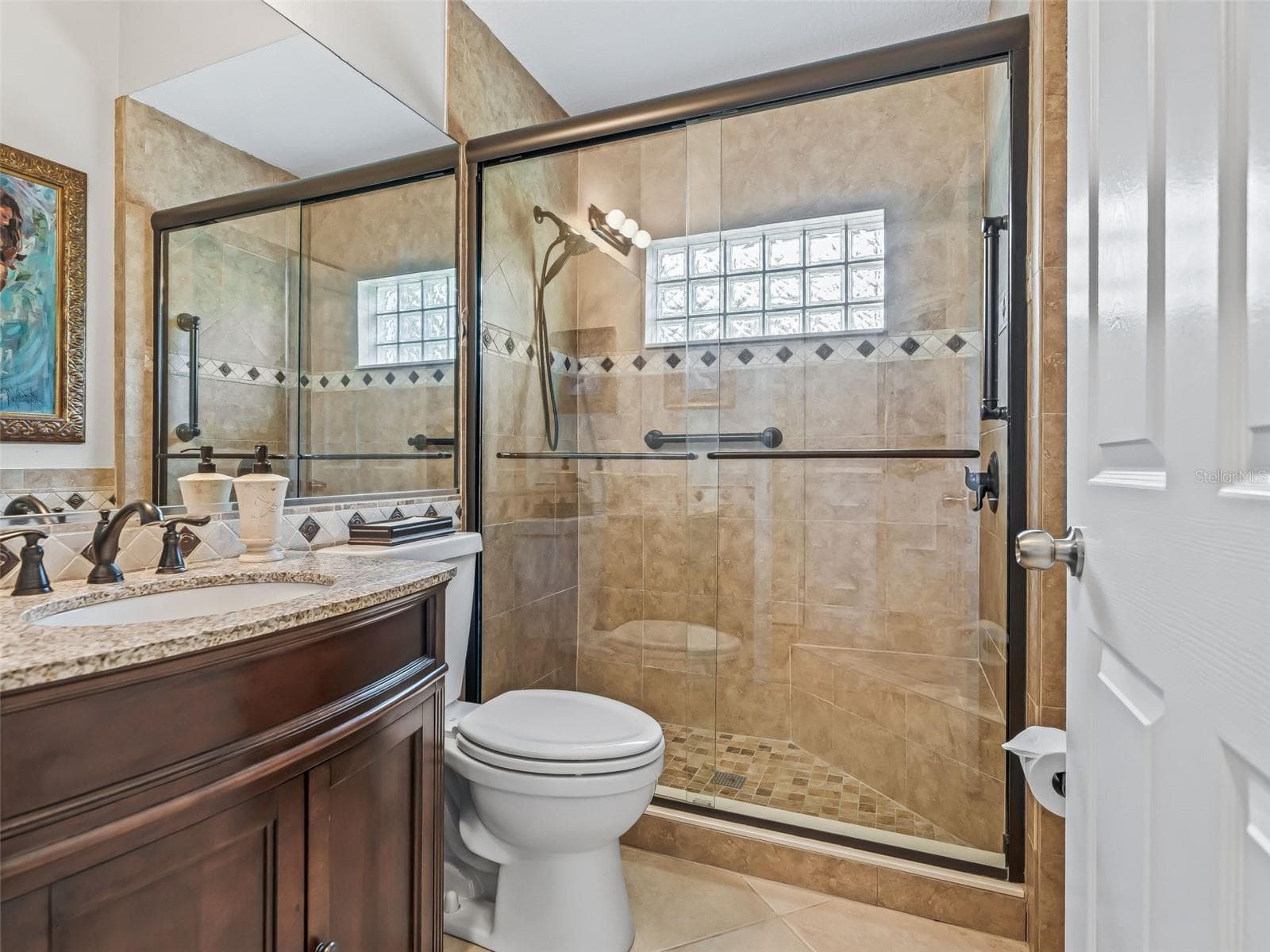 The spacious guest bath features a beautiful granite-topped vanity and an upgraded walk-in shower with attractive tilework and glass enclosure. - 714 CIMARRON AVE, THE VILLAGES