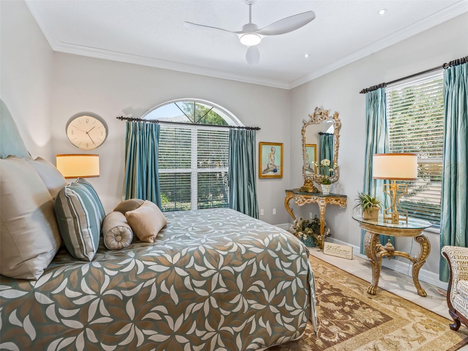 Generously sized 14.2'x13' guest bedroom features abundant natural light, an arched window, upgraded ceiling fan, luxury vinyl plank flooring, and plenty of room for visiting family and friends. - 714 CIMARRON AVE, THE VILLAGES