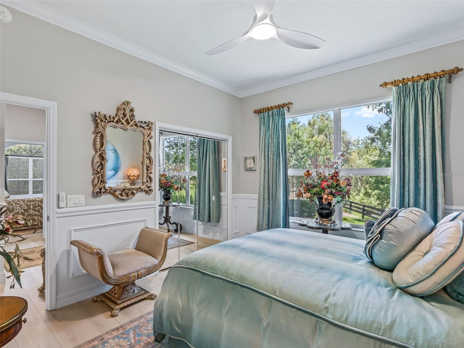 Large windows fill this guest bedroom with natural light while providing pleasant views of the home's lush landscaping and private surroundings. - 714 CIMARRON AVE, THE VILLAGES