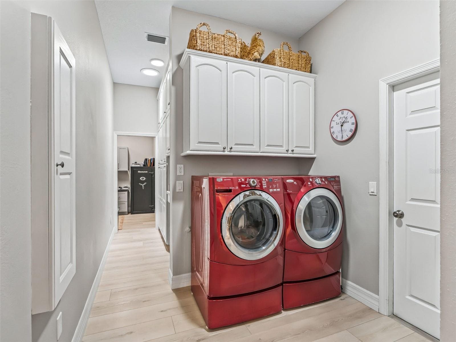 The laundry area features side-by-side washer and dryer, overhead cabinetry for added storage, and easy access to the home's butler's pantry and additional utility spaces. - 714 CIMARRON AVE, THE VILLAGES