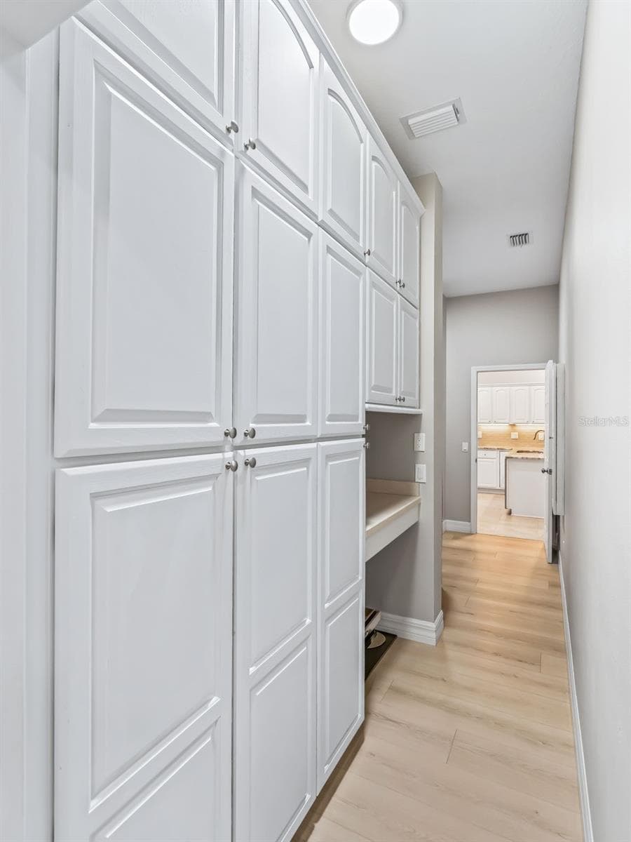 The butler's pantry continues with floor-to-ceiling cabinetry, creating an extraordinary amount of organized storage just off the kitchen and laundry area. - 714 CIMARRON AVE, THE VILLAGES